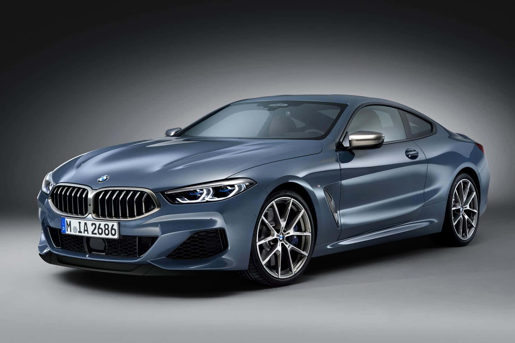 Bmw 8 Series 桌布 壁紙 — 一輛時尚的金屬藍色BMW 8系轎跑車在漸變灰色背景下的攝影棚燈光中閃閃發光。