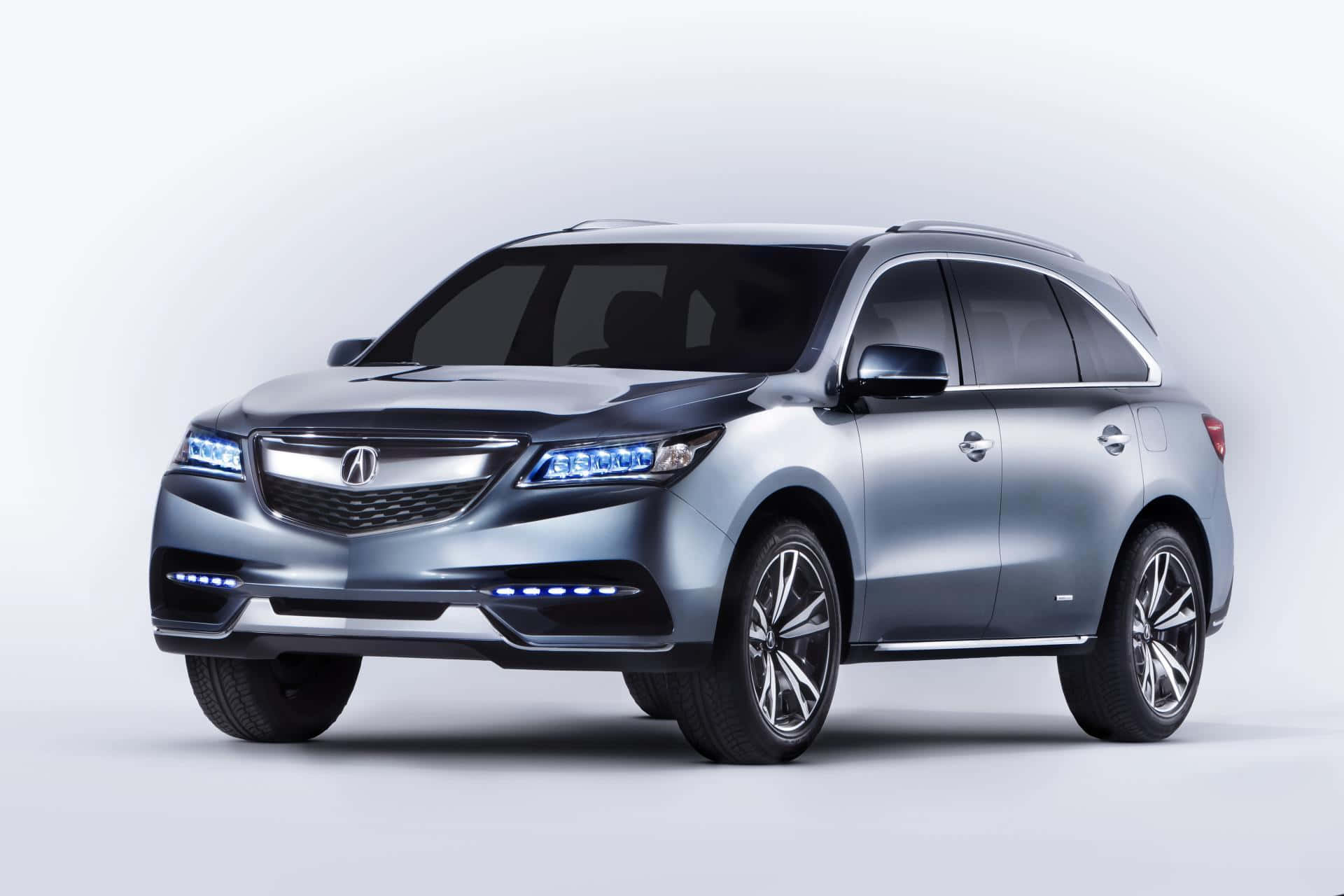 Acura Mdx 桌布 壁紙 — 一輛時尚的銀色Acura SUV，配備發光的藍色頭燈，在極簡的白色工作室背景前蓄勢待發。