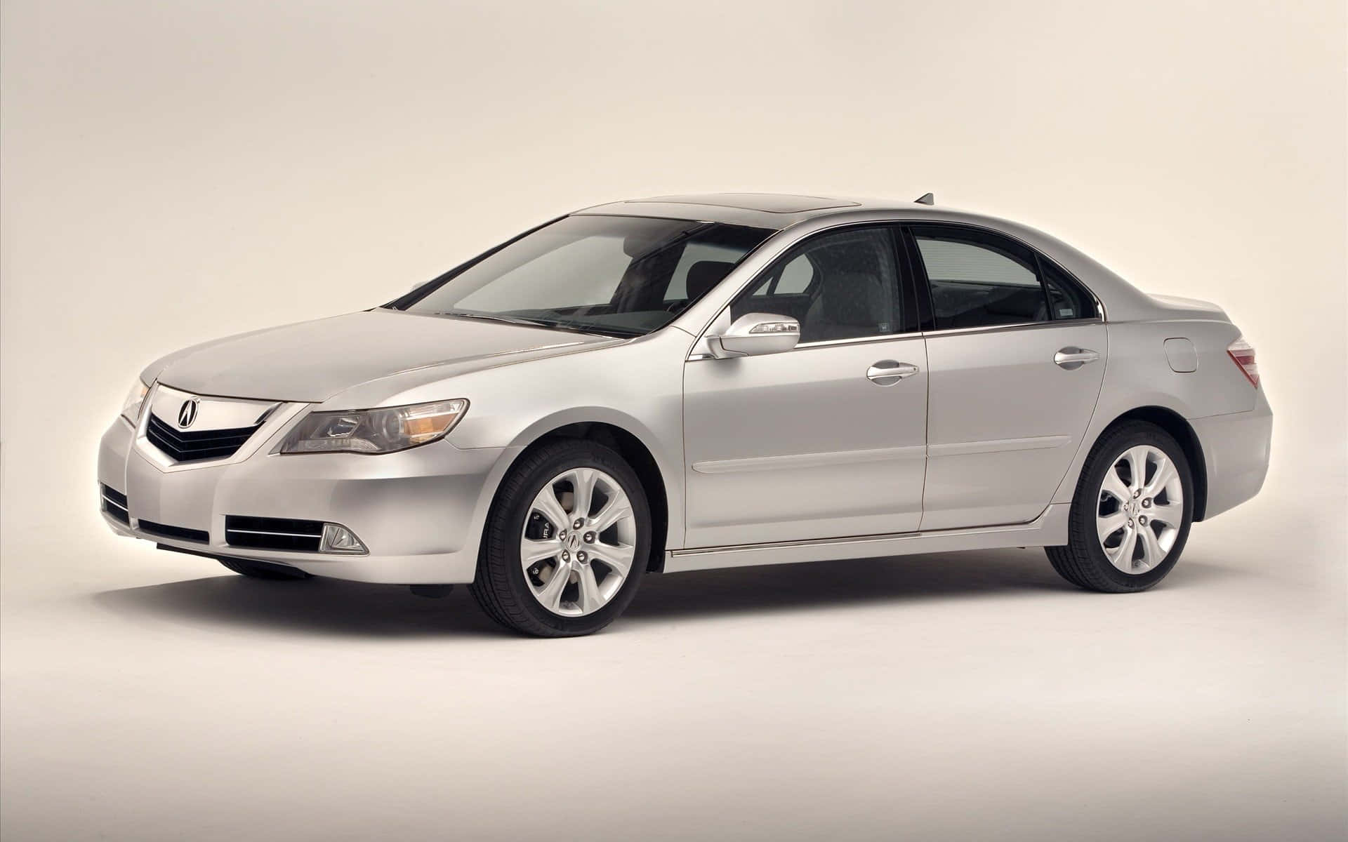 Acura Rl 桌布 壁紙 — 一輛時尚的銀色Acura轎車在簡潔的攝影棚背景中側面展示，光線柔和。