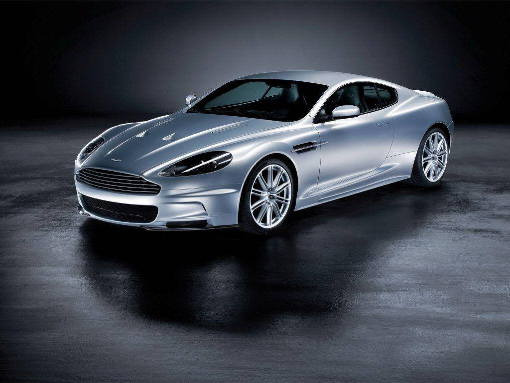 Sports Car 桌布 壁紙 — 一輛時尚的銀色Aston Martin DB9雙門跑車在攝影棚燈光下，在深色反光地板上閃閃發光。
