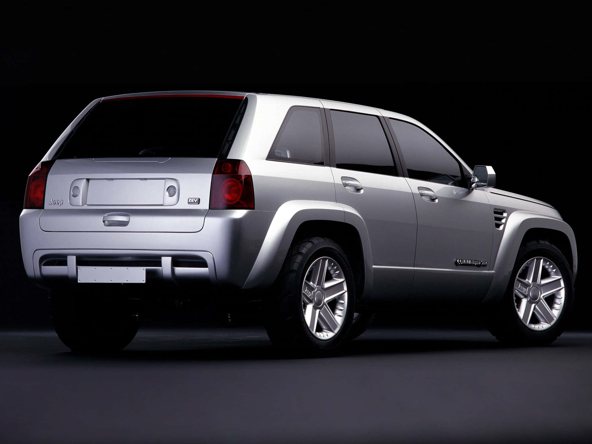 Jeep Commander 桌布 壁紙 — 一輛時尚的銀色Jeep Grand Cherokee SUV在黑色背景下的攝影棚燈光中展示。