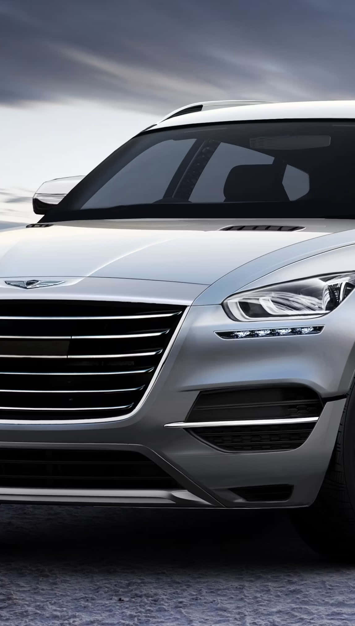 Genesis Gv80 桌布 壁紙 — 一輛時尚的銀色SUV，配有大膽的格柵和鋒利的頭燈，在陰沉多雲的天空下蓄勢待發。