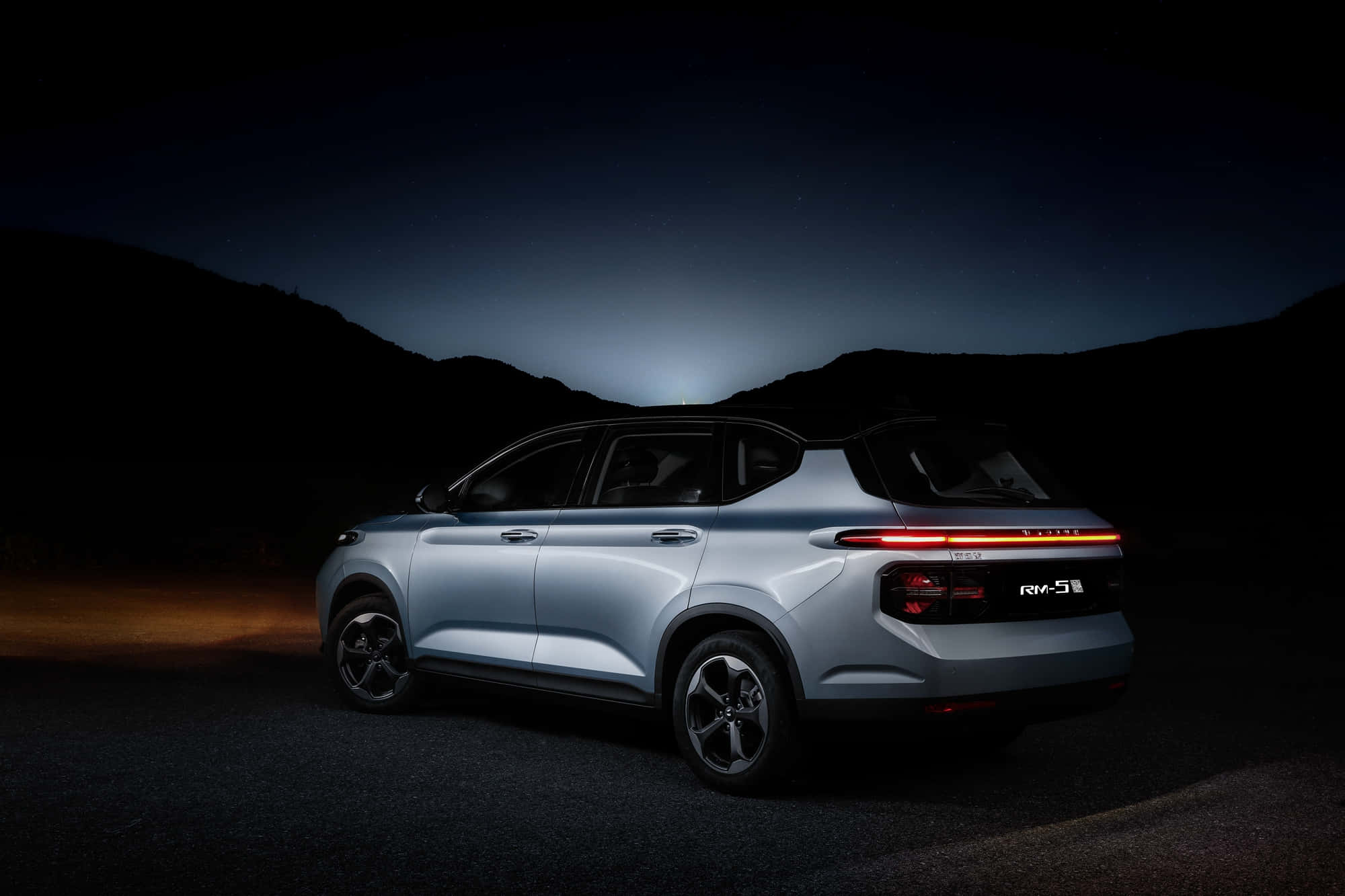 Baojun 桌布 壁紙 — 一輛時尚的銀色SUV在夜晚停泊於星空下，尾燈在黑暗的山丘前閃爍發光。