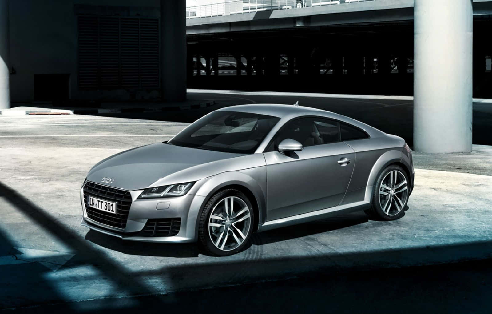 Audi Tt 桌布 壁紙 — 一輛時尚的銀色奧迪TT雙門跑車停放在混凝土天橋下，帶有戲劇性的陰影和冷藍色燈光。