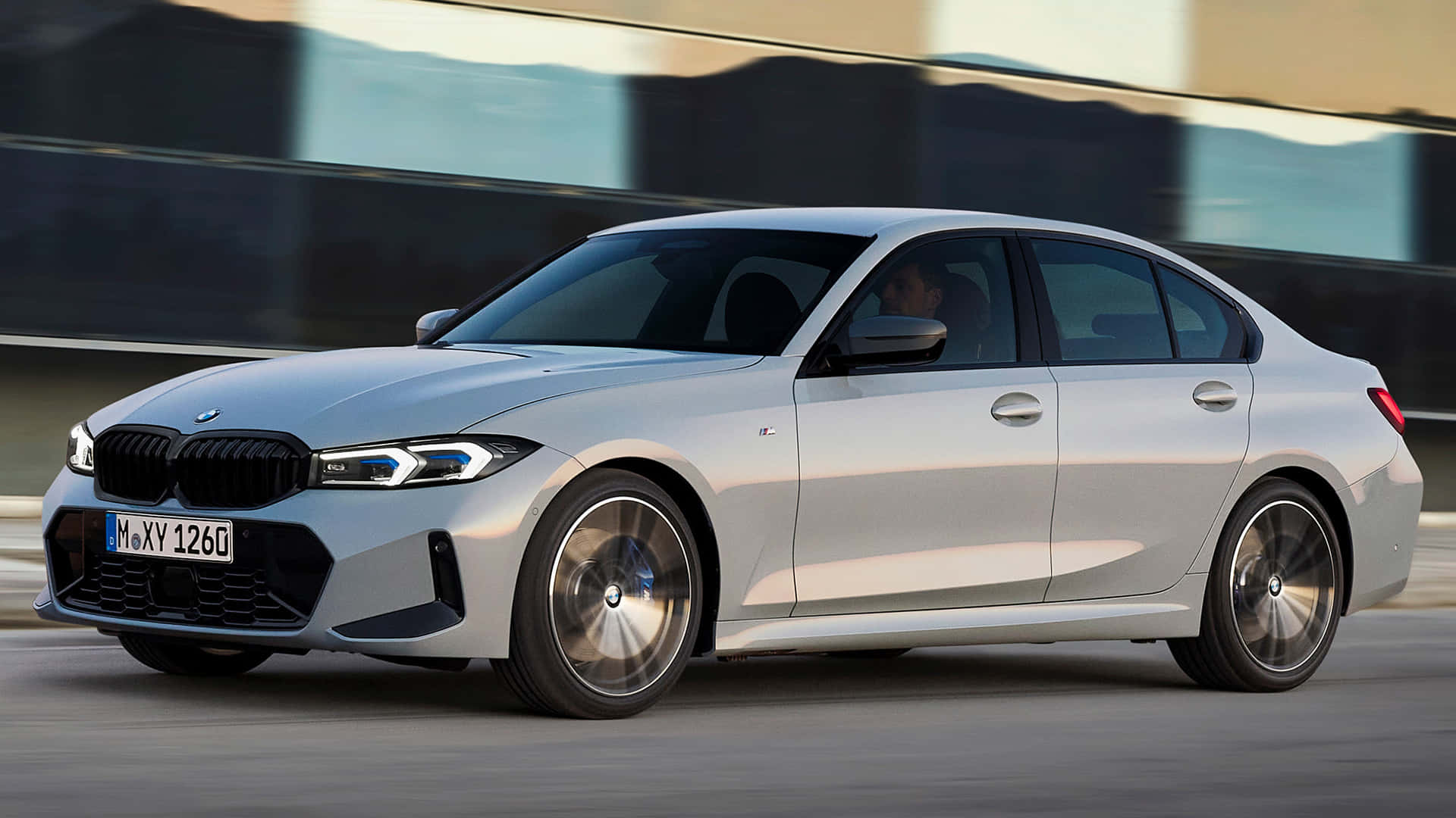 Bmw 3 Series 桌布 壁紙 — 一輛時尚的銀色寶馬3系轎車在現代高速公路上疾馳，帶有模糊的動感和反光表面。