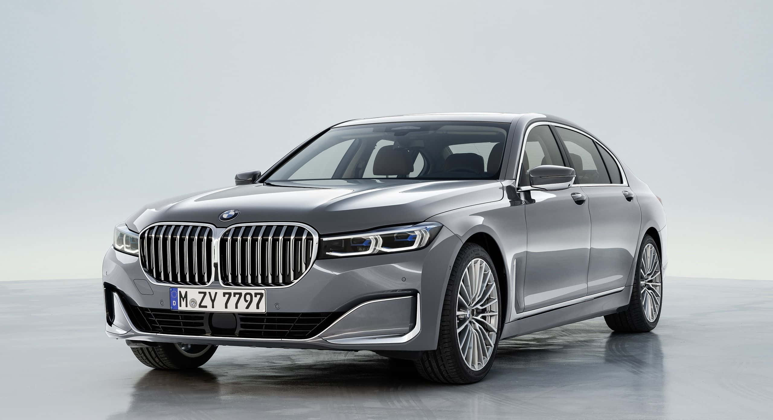 Bmw 7 Series 桌布 壁紙 — 一輛時尚的銀色寶馬7系轎車在攝影棚燈光下，在極簡灰色背景前閃閃發光。