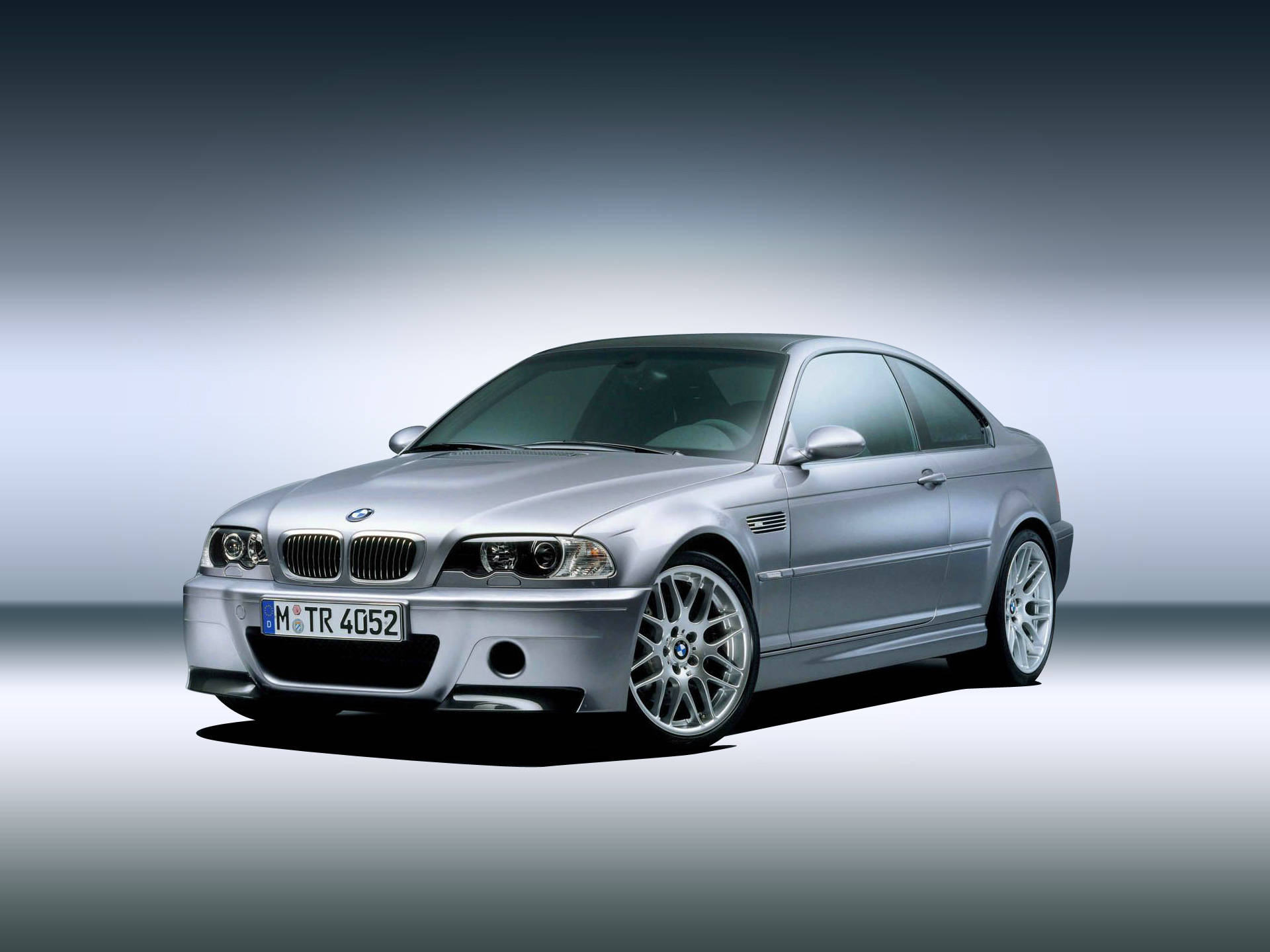 classic bmw 桌布 壁紙 — 一輛時尚的銀色寶馬M3轎跑車在攝影棚燈光下，在漸變灰色背景上閃閃發光。