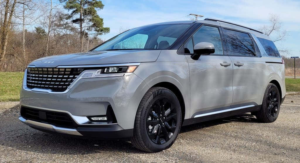 Family Car 桌布 壁紙 — 一輛時尚的銀色小型貨車帶有黑色飾邊，停在碎石路上，旁邊是樹林地區，上方是清澈的藍天。