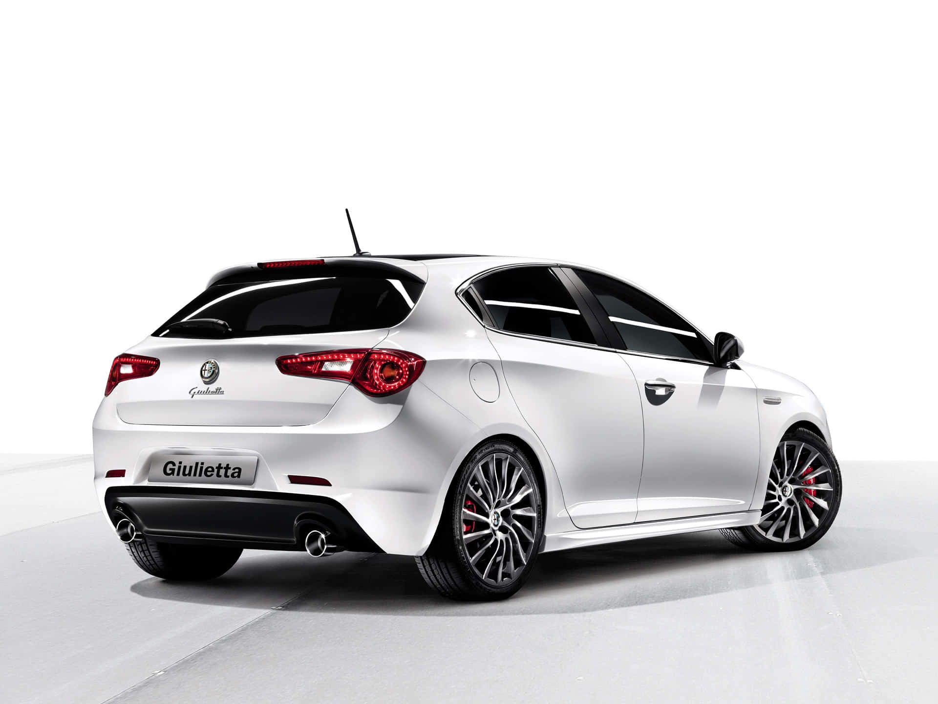 Alfa Romeo Giulietta 桌布 壁紙 — 一輛時尚的銀色愛快羅密歐 Giulietta 掀背車，以車尾四分之三角度展示，背景為簡約的白色工作室。