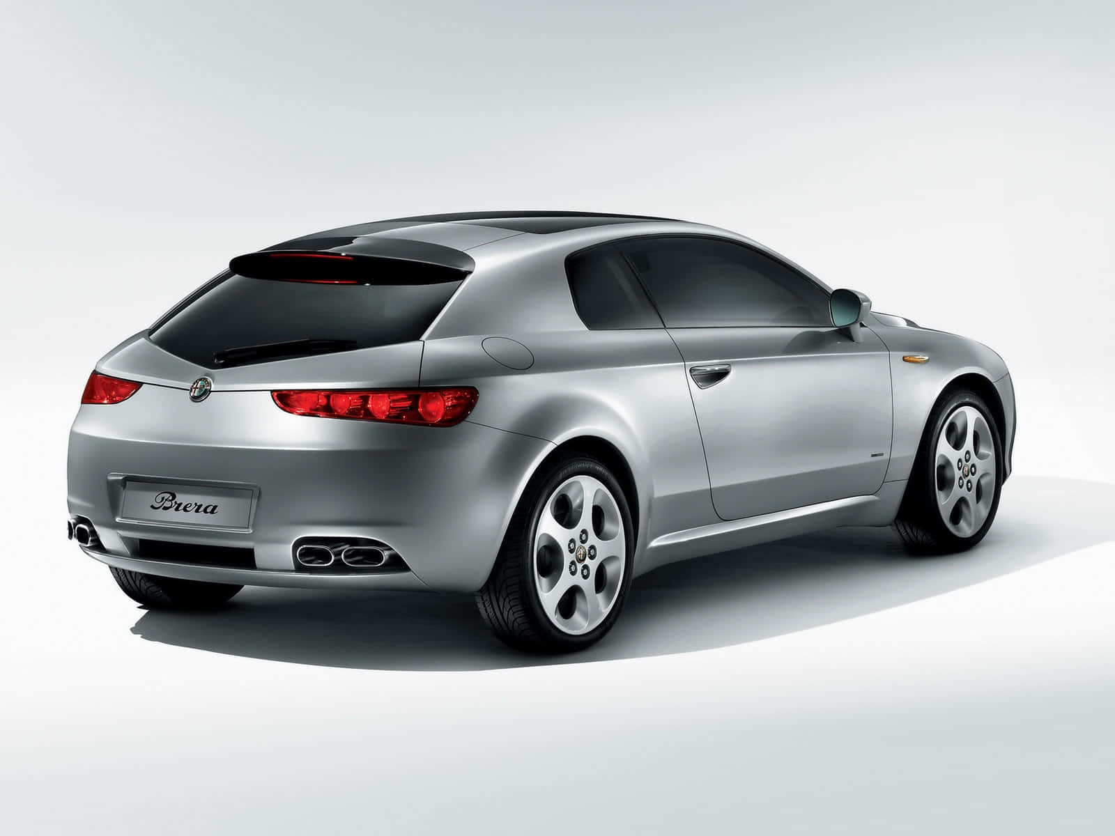 Alfa Romeo Brera 桌布 壁紙 — 一輛時尚的銀色愛快羅密歐Brera運動轎跑車，以四分之三後視角度呈現，背景為簡約的白色工作室。