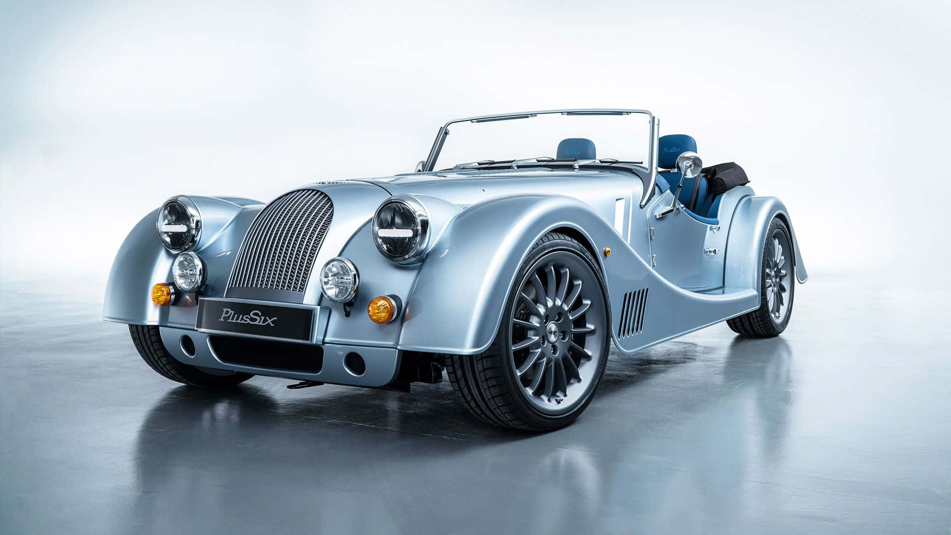 Morgan 桌布 壁紙 — 一輛時尚的銀色摩根Plus Six開篷跑車，配備藍色內飾，在簡約的攝影棚環境中展示。