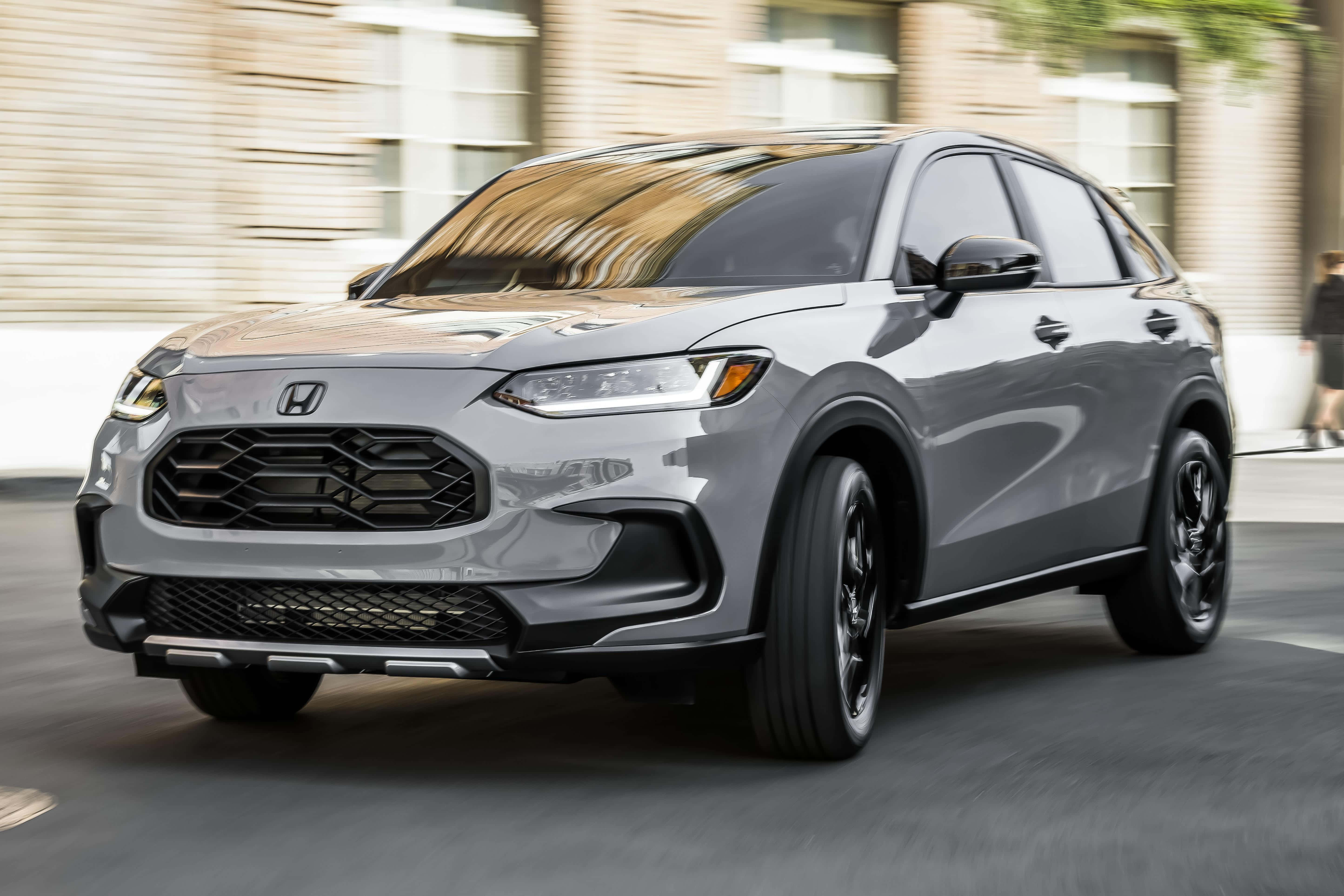 Honda Hr-v 桌布 壁紙 — 一輛時尚的銀色本田SUV在城巿街道上飛馳，背景建築物呈現動態模糊效果。