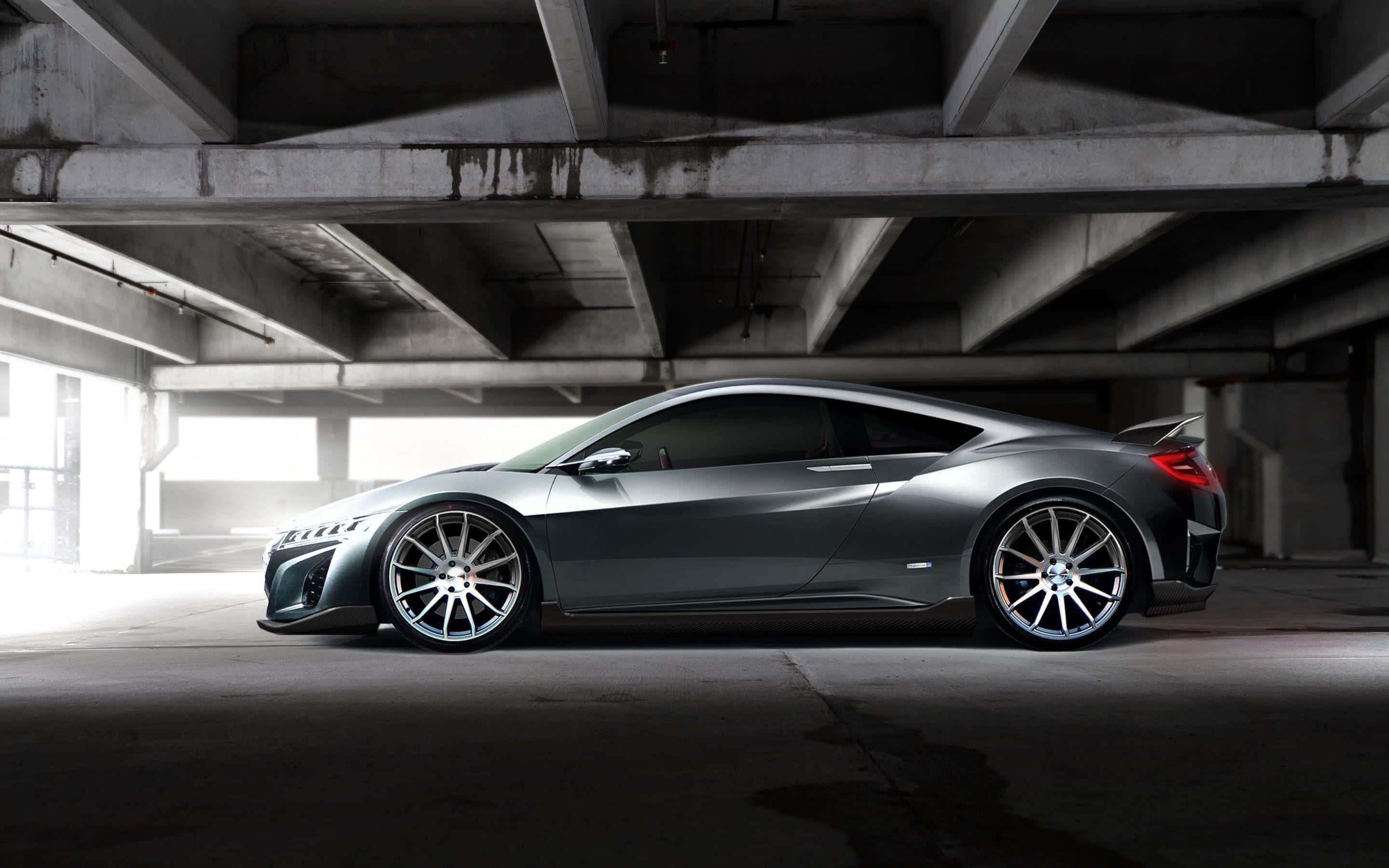 Acura Nsx 桌布 壁紙 — 一輛時尚的銀色跑車停放在混凝土天橋下，帶有戲劇性的燈光效果。