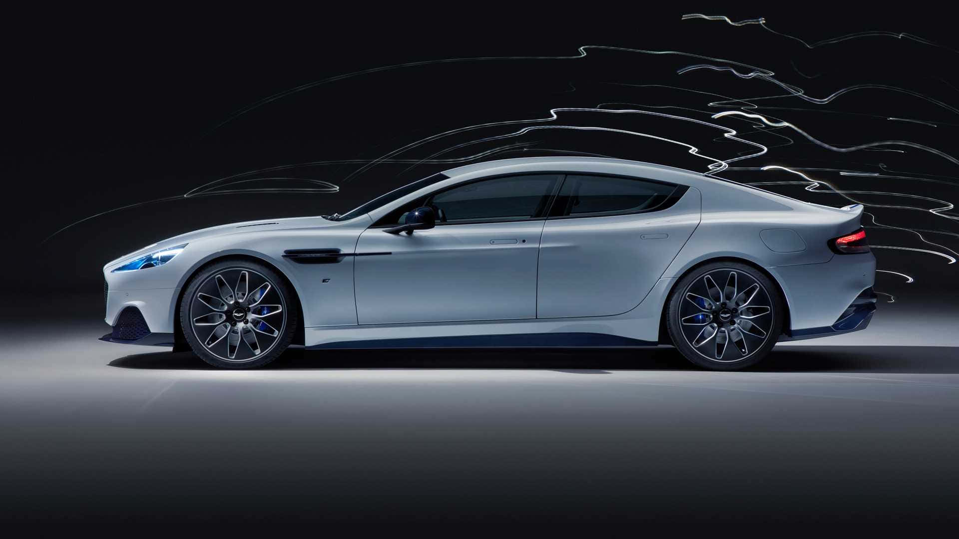 Aston Martin Rapide S 桌布 壁紙 — 一輛時尚的銀色跑車在黑暗的工作室背景下，沿著風格化的運動線條滑行。