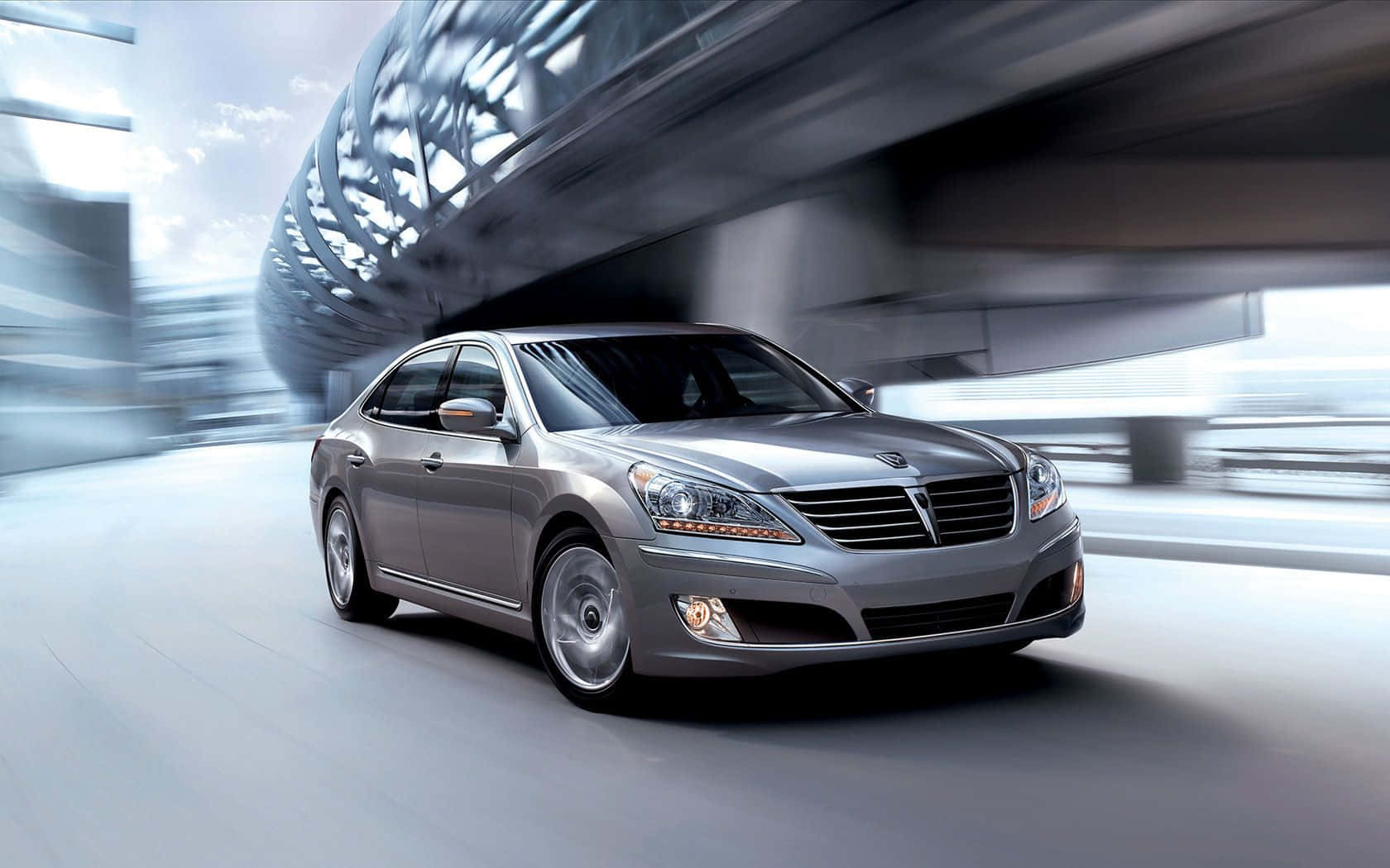 Hyundai Equus 桌布 壁紙 — 一輛時尚的銀色轎車在現代城市隧道中疾馳，動態模糊強調了速度。