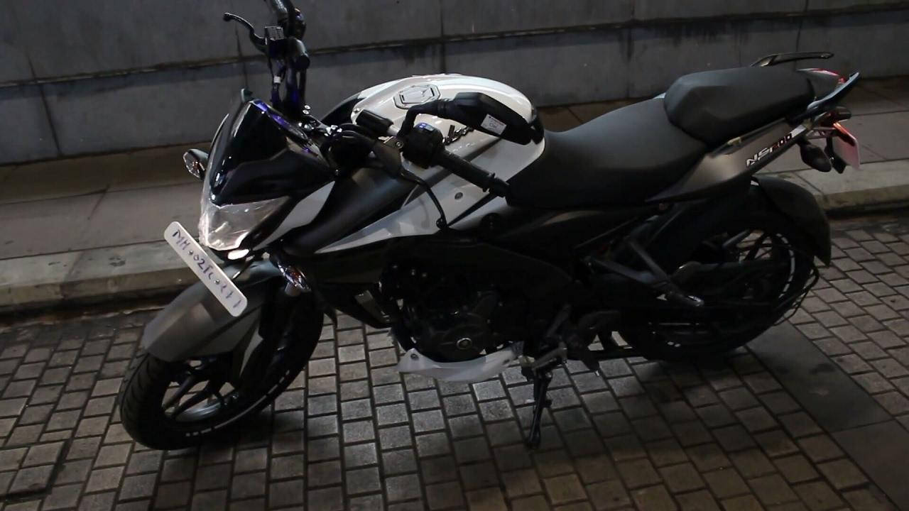 機車 桌布 壁紙 — 一輛時尚的黑白電單車停在磚砌路面上，處於人造夜間燈光下。
