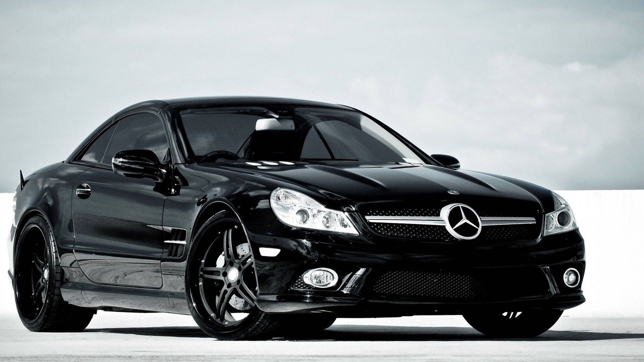 HD 桌布 壁紙 — 一輛時尚的黑色 Mercedes SLR McLaren 跑車在明亮的攝影棚燈光下，在極簡的白色背景上閃閃發光。