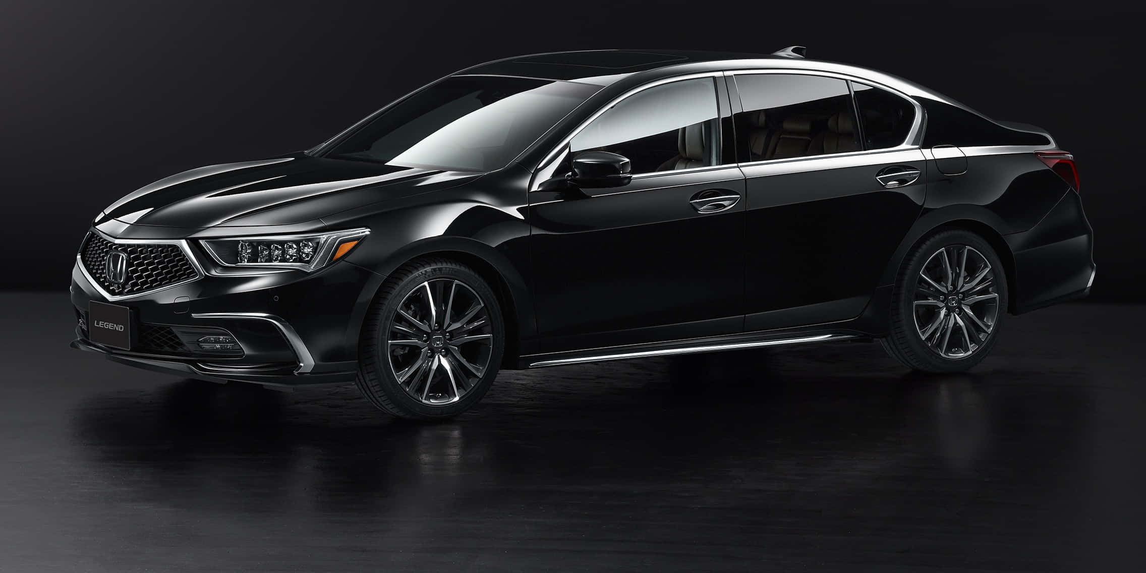 Honda Legend 桌布 壁紙 — 一輛時尚的黑色Acura Legend轎車在攝影棚燈光下，在深色反光地板上閃閃發光。