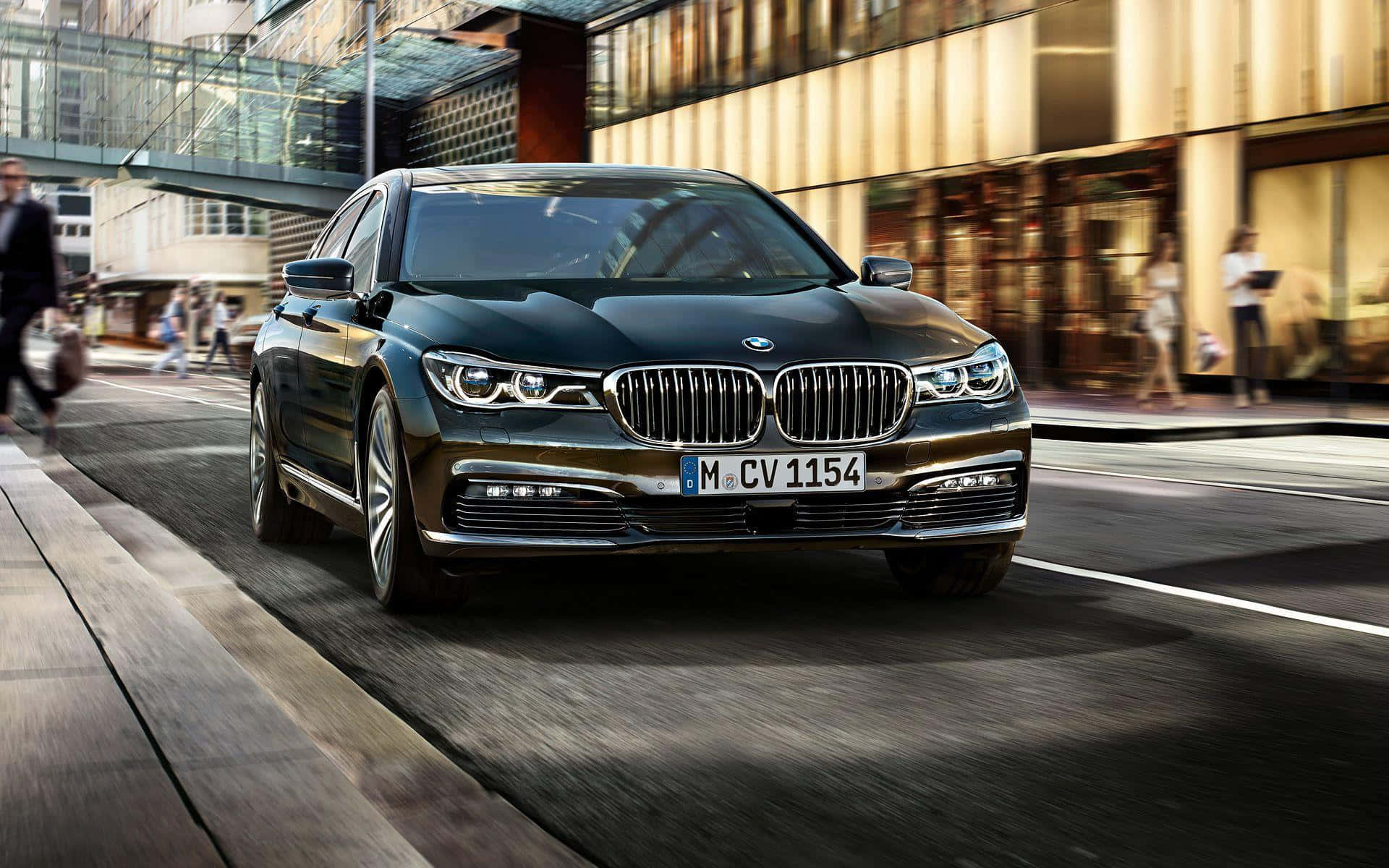 Bmw 7 Series 桌布 壁紙 — 一輛時尚的黑色BMW 7系轎車在繁華的城市街道上行駛，背景建築物和行人呈現動態模糊效果。