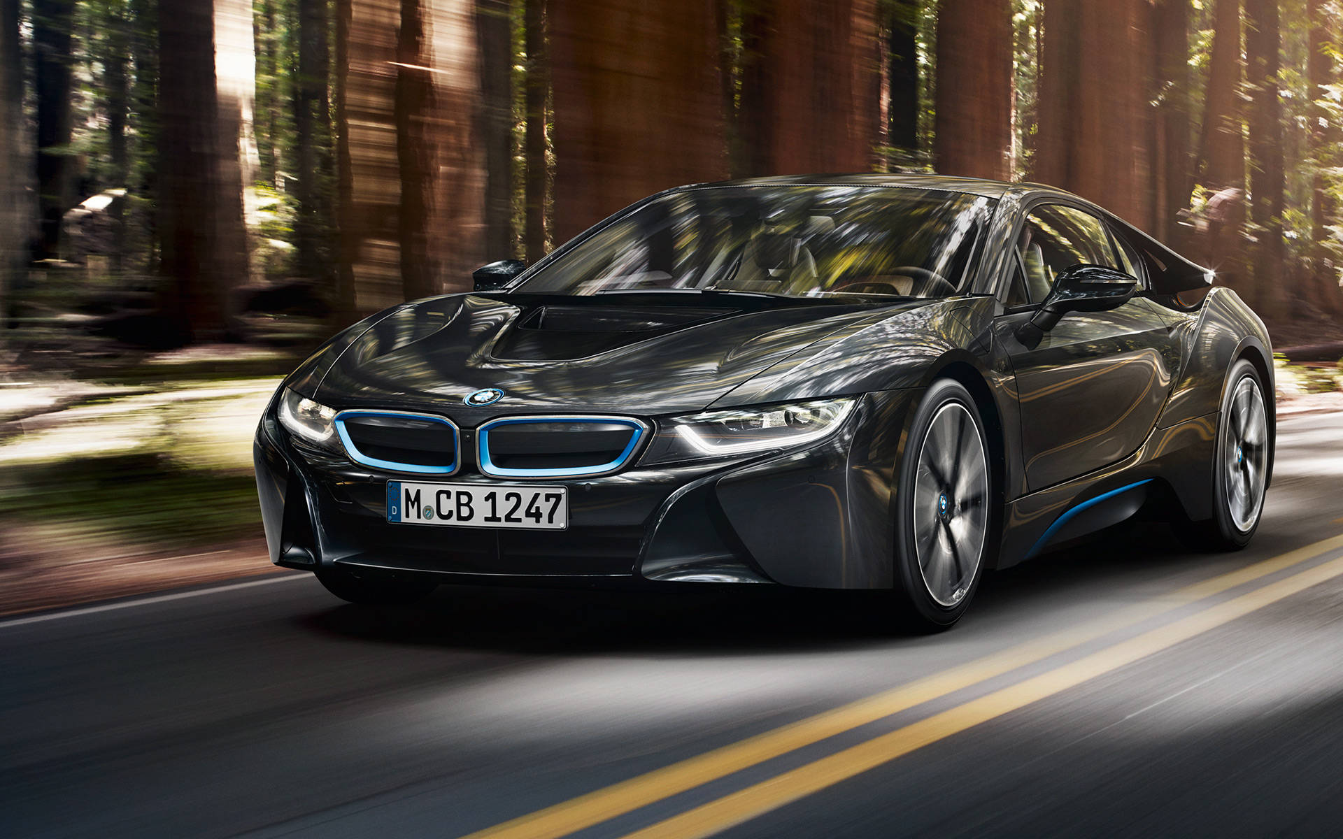woods 桌布 壁紙 — 一輛時尚的黑色BMW i8跑車在陽光明媚的森林中飛馳，道路和樹木呈現動態模糊效果。