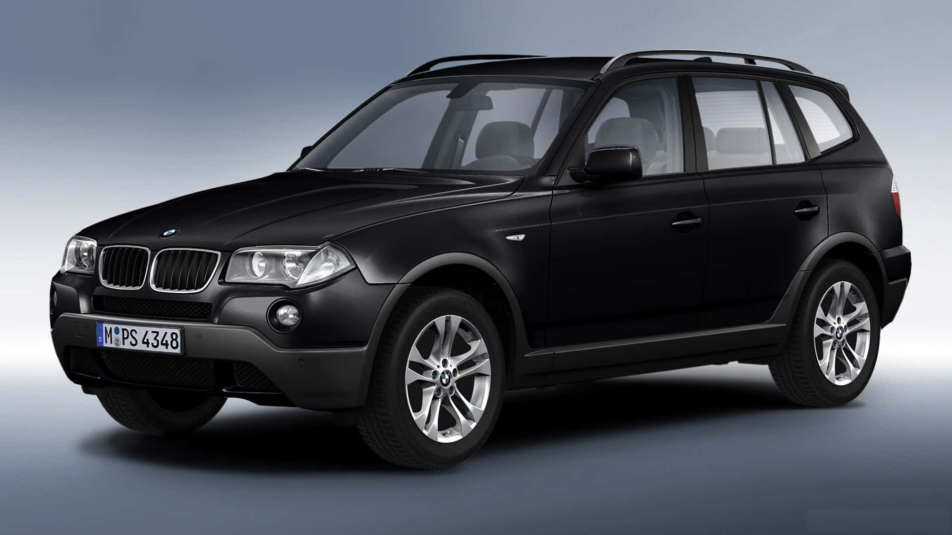 Bmw X3 桌布 壁紙 — 一輛時尚的黑色BMW X3 SUV在攝影棚內以柔和燈光和漸變灰色背景展示。