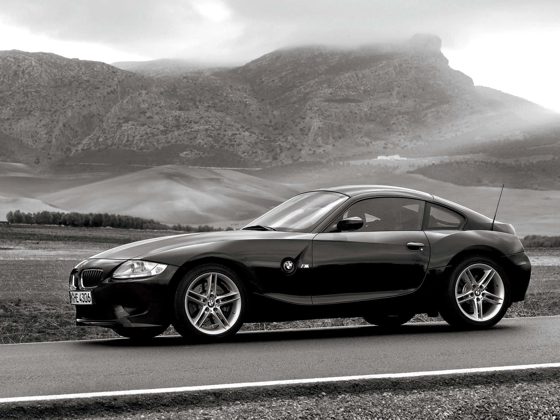 Bmw Z4 桌布 壁紙 — 一輛時尚的黑色BMW Z4 M轎跑車停在路邊，背景是霧氣繚繞的山巒。