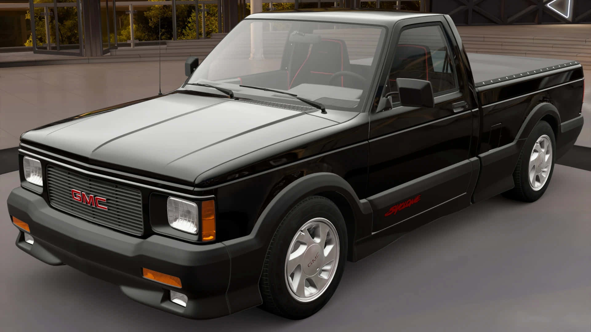Gmc Syclone 桌布 壁紙 — 一輛時尚的黑色GMC皮卡車，帶有紅色點綴和銀色輪圈，在現代室內工作室環境中展示。