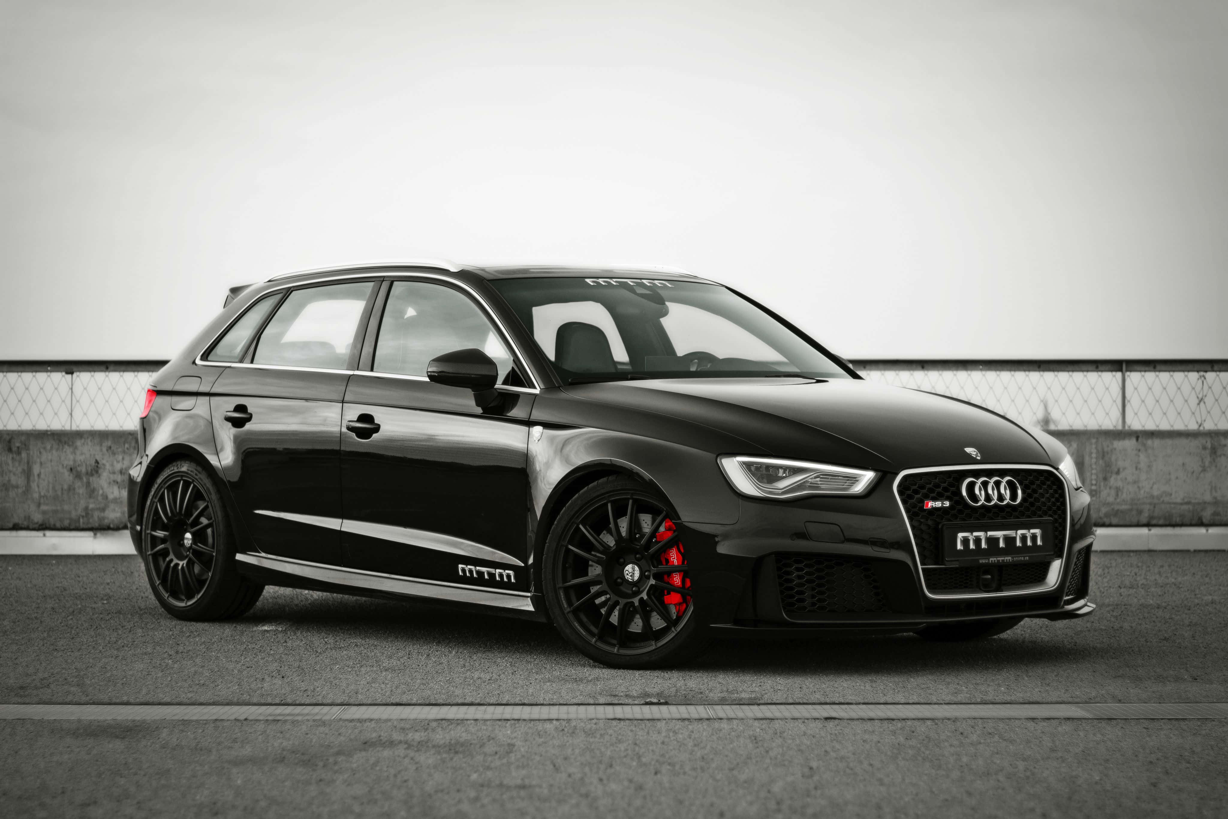 Audi Rs3 桌布 壁紙 — 一輛時尚的黑色MTM改裝奧迪S3跑車，配備紅色制動卡鉗，停在灰色瀝青路面上。