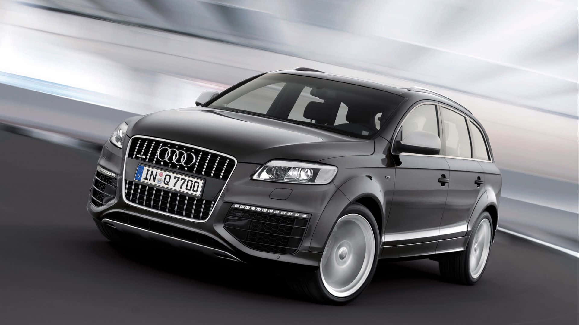 Audi Q7 桌布 壁紙 — 一輛時尚的黑色奧迪Q7 SUV在背景中帶着動態模糊條紋向前飛馳。