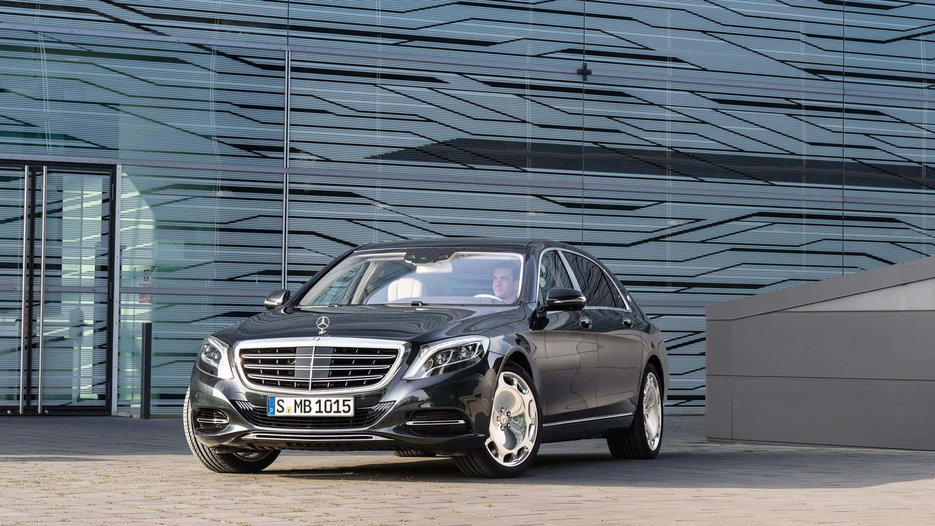 Maybach 桌布 壁紙 — 一輛時尚的黑色平治S-Class房車停在現代幾何圖案玻璃建築前。