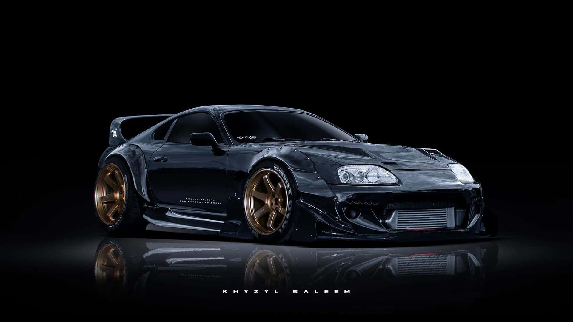 Supra 桌布 壁紙 — 一輛時尚的黑色改裝跑車配金色輪圈，在黑色背景和反光地板上戲劇性地展示。