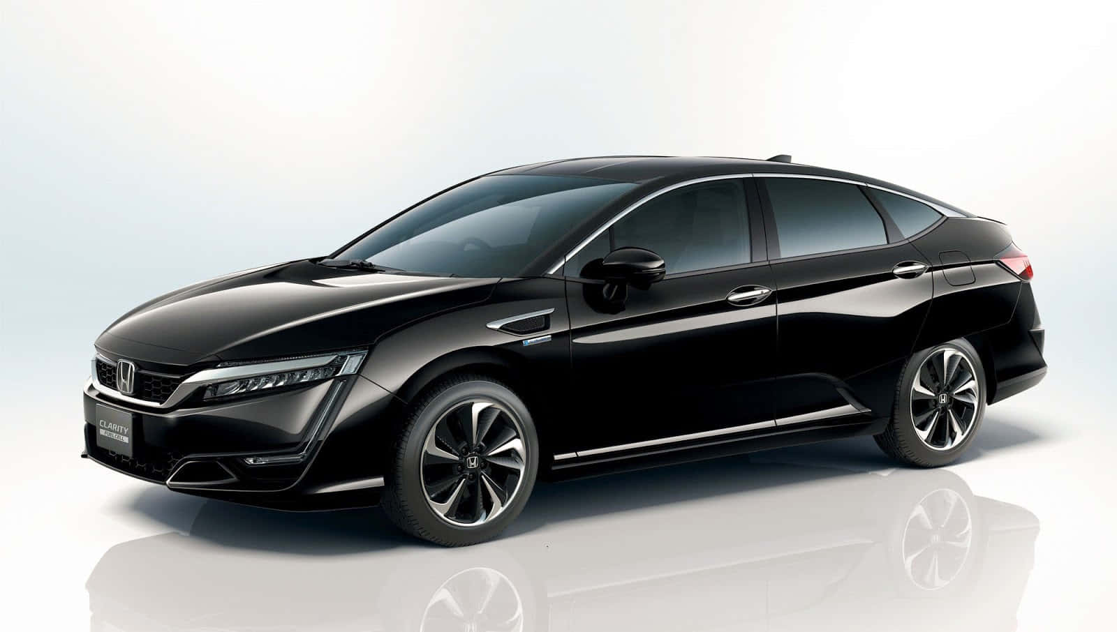 Honda Clarity 桌布 壁紙 — 一輛時尚的黑色本田Clarity轎車在攝影棚燈光下閃耀，反射在白色地板上。