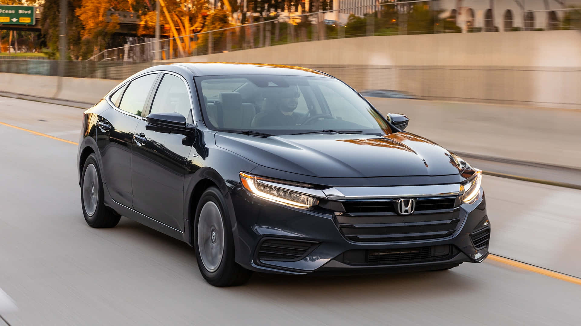 Honda Insight 桌布 壁紙 — 一輛時尚的黑色本田房車在陽光明媚的高速公路上疾馳，背景呈現動態模糊效果。