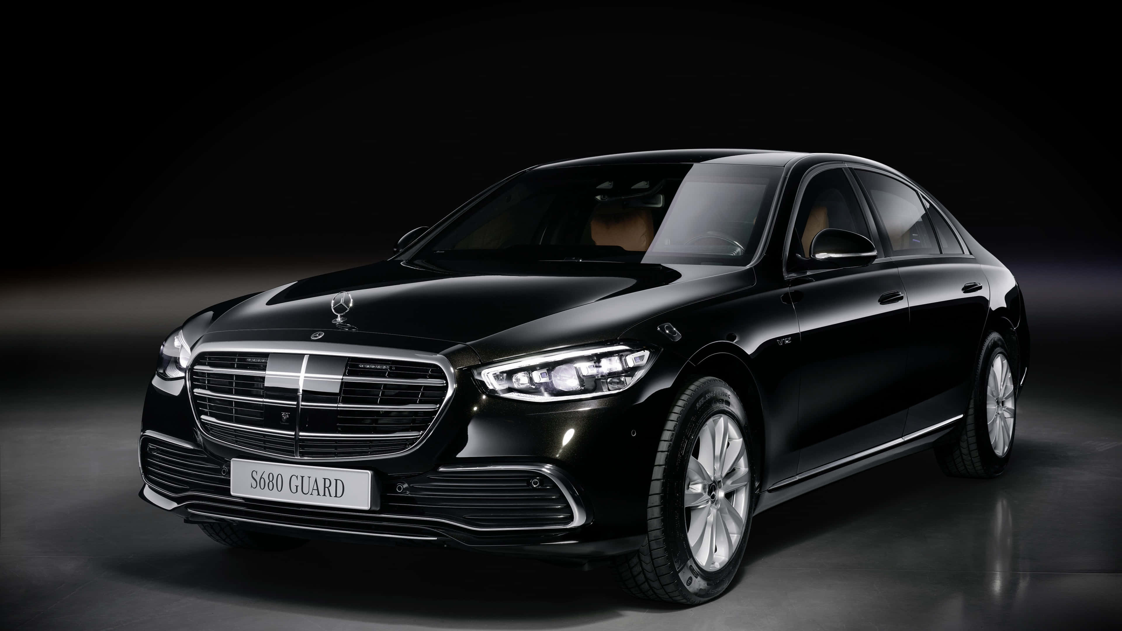 4K Mercedes 桌布 壁紙 — 一輛時尚的黑色梅賽德斯 S680 Guard 豪華轎車在暗色漸變背景前的攝影棚燈光下閃閃發光。