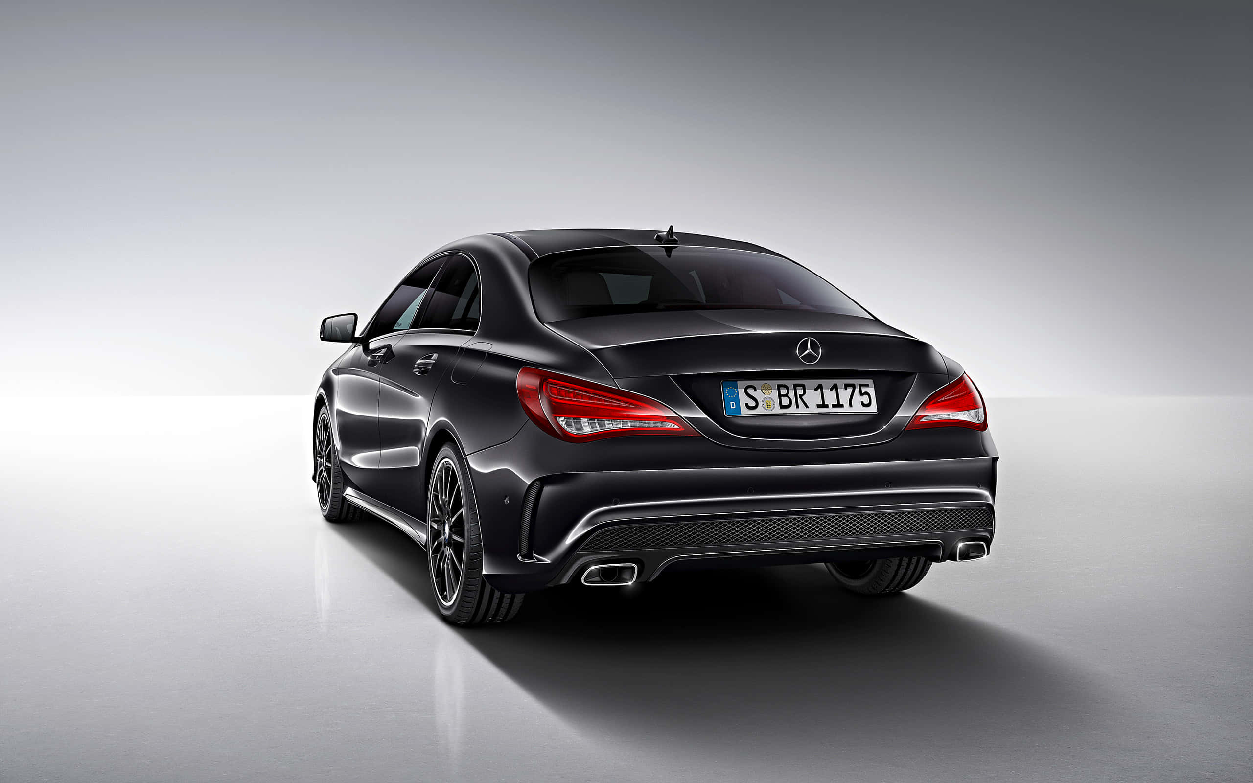Mercedes Benz Cla-class 桌布 壁紙 — 一輛時尚的黑色梅賽德斯-奔馳CLA轎跑車在攝影棚燈光下閃耀，紅色尾燈和雙排氣管，背景為簡約灰色。