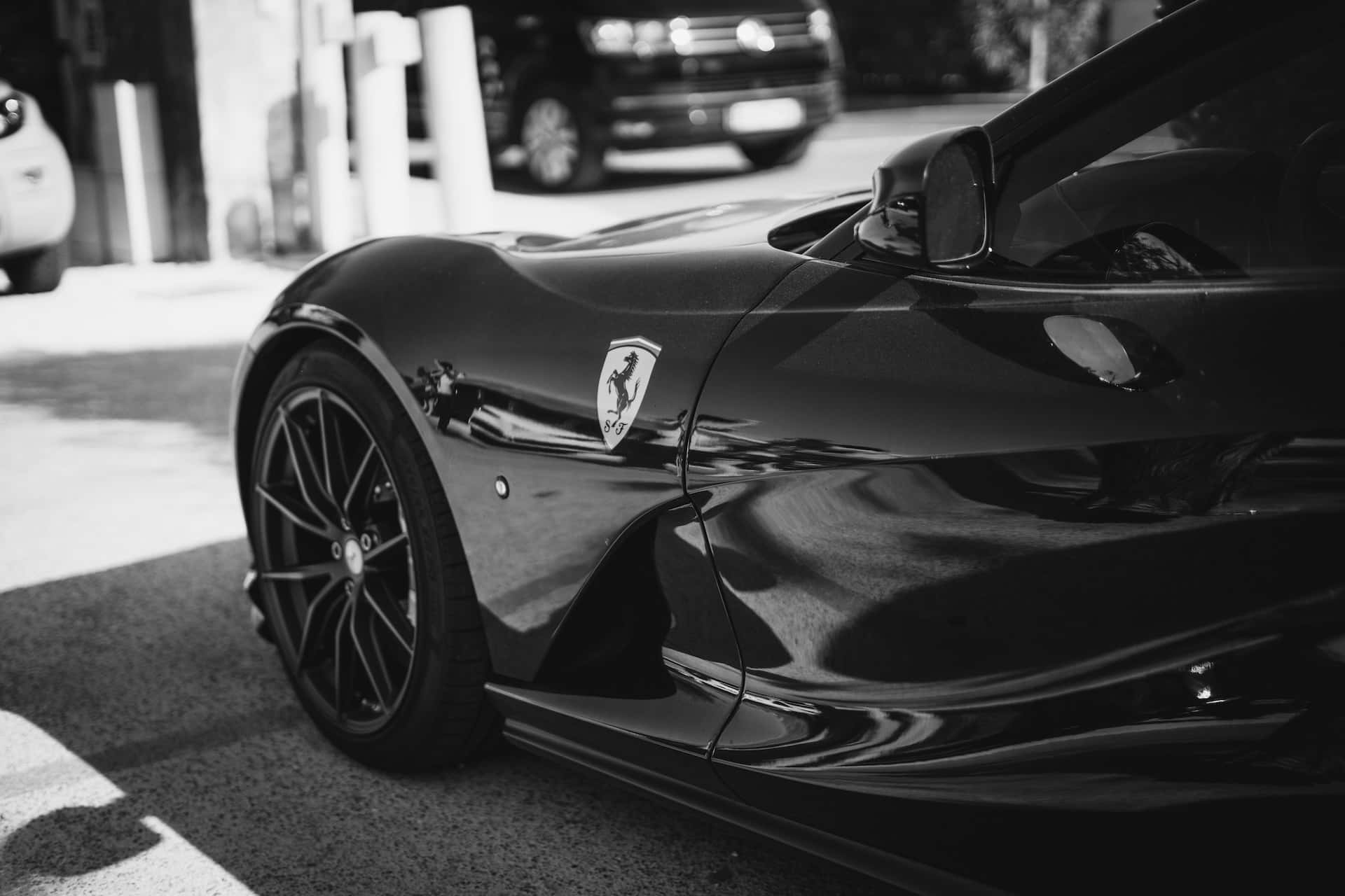 Black And White Car 桌布 壁紙 — 一輛時尚的黑色法拉利跑車在車庫中閃耀，單色調中展現銳利線條和反射曲線。