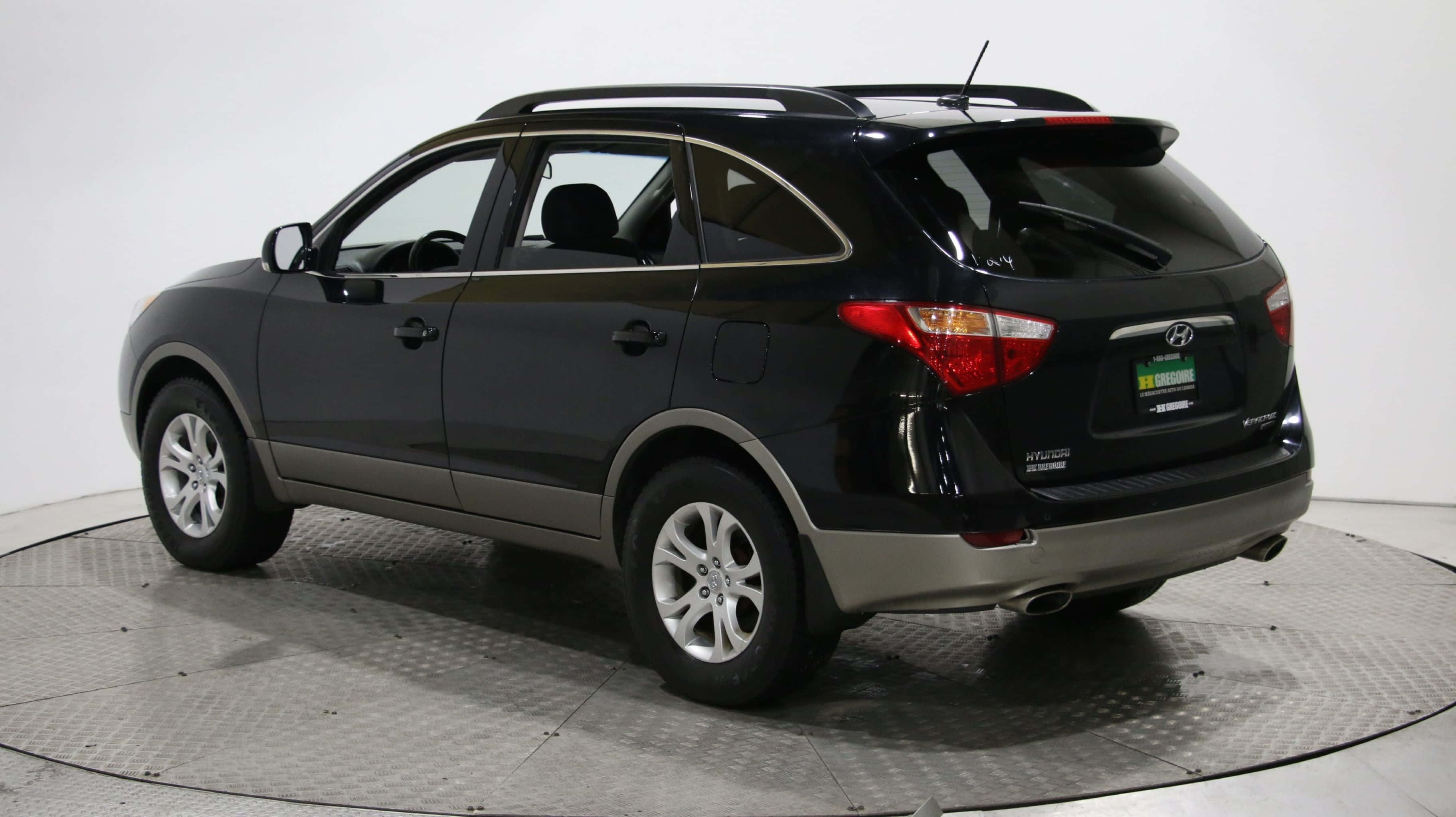 Hyundai Veracruz 桌布 壁紙 — 一輛時尚的黑色現代 Santa Fe SUV 從後方四分之三角度拍攝，位於圓形金屬平台上，背景為純白色攝影棚。