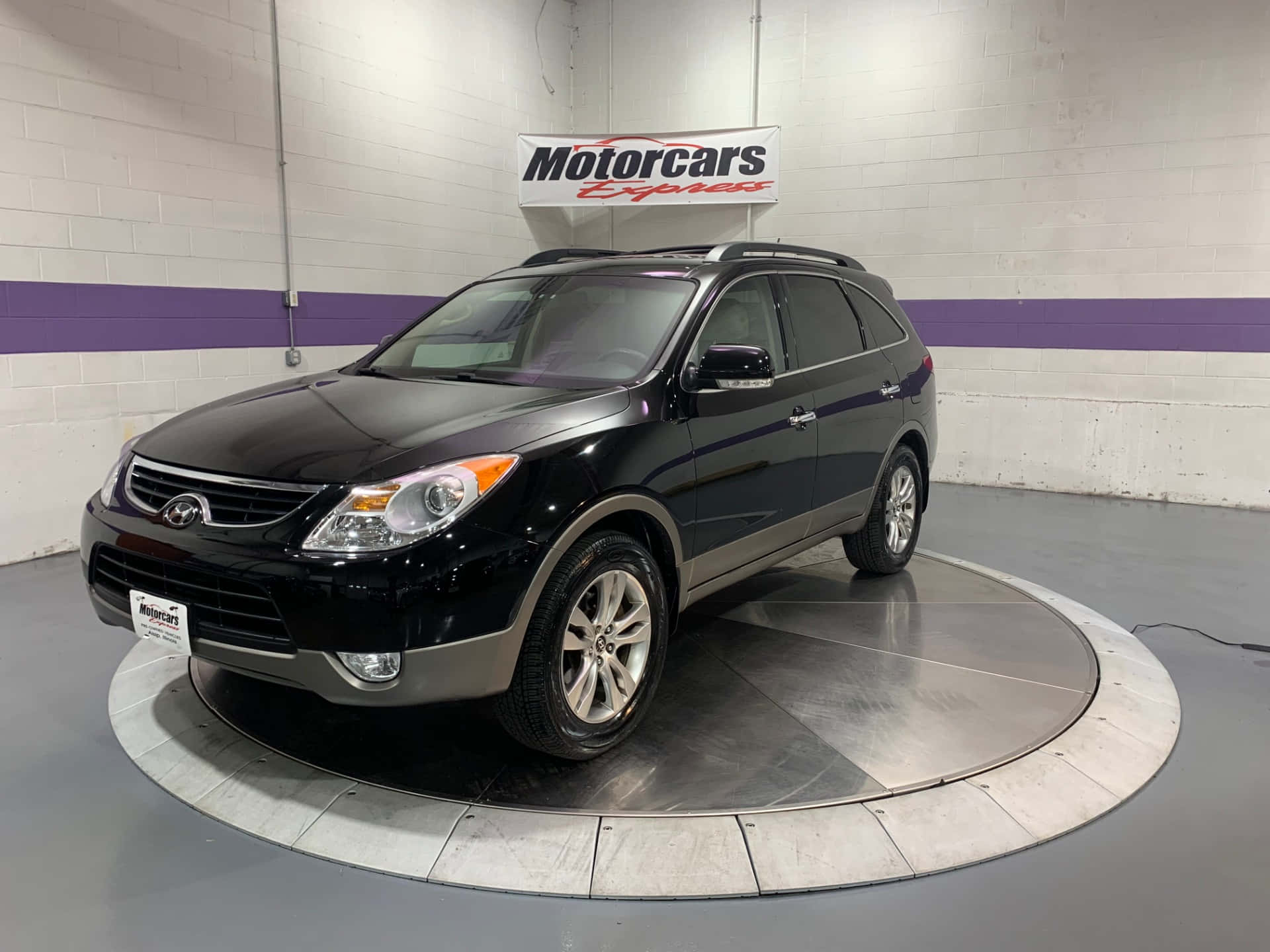 Hyundai Veracruz 桌布 壁紙 — 一輛時尚的黑色現代Santa Fe SUV在光線充足的汽車經銷商展廳內的圓形轉盤上展示。