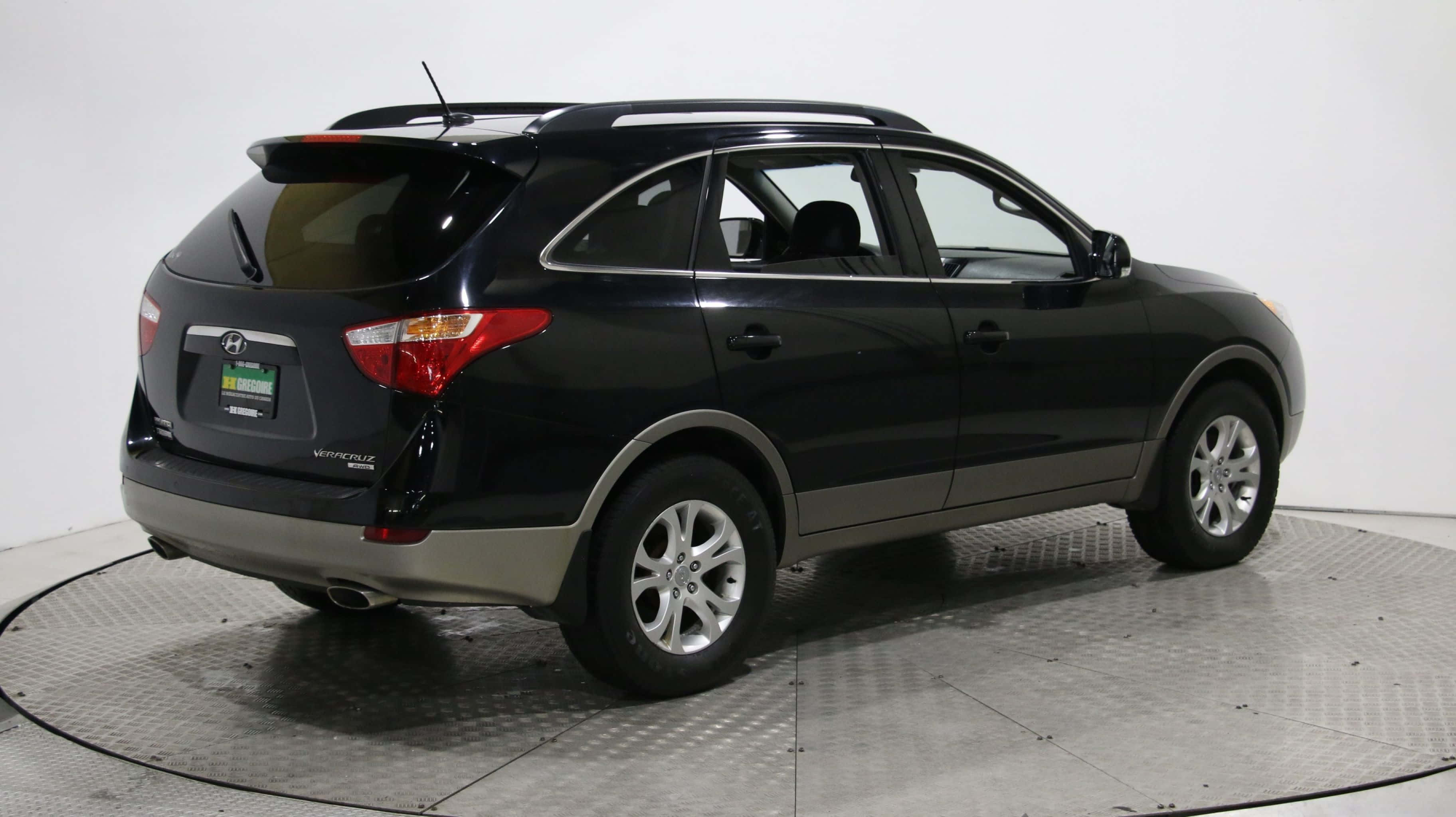 Hyundai Veracruz 桌布 壁紙 — 一輛時尚的黑色現代Tucson SUV在圓形金屬平台上，以白色純淨工作室背景從後方四分之三角度拍攝。
