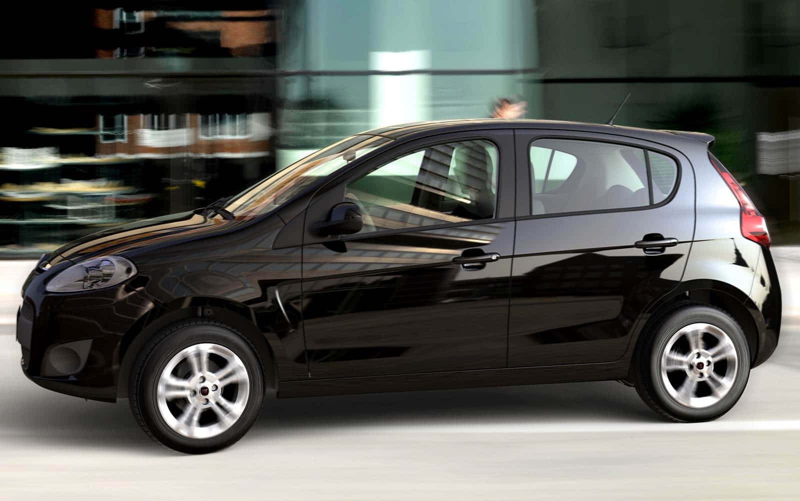 Fiat Palio 桌布 壁紙 — 一輛時尚的黑色緊湊型汽車高速駛過一座模糊的現代玻璃建築，建築反射著城市燈光。