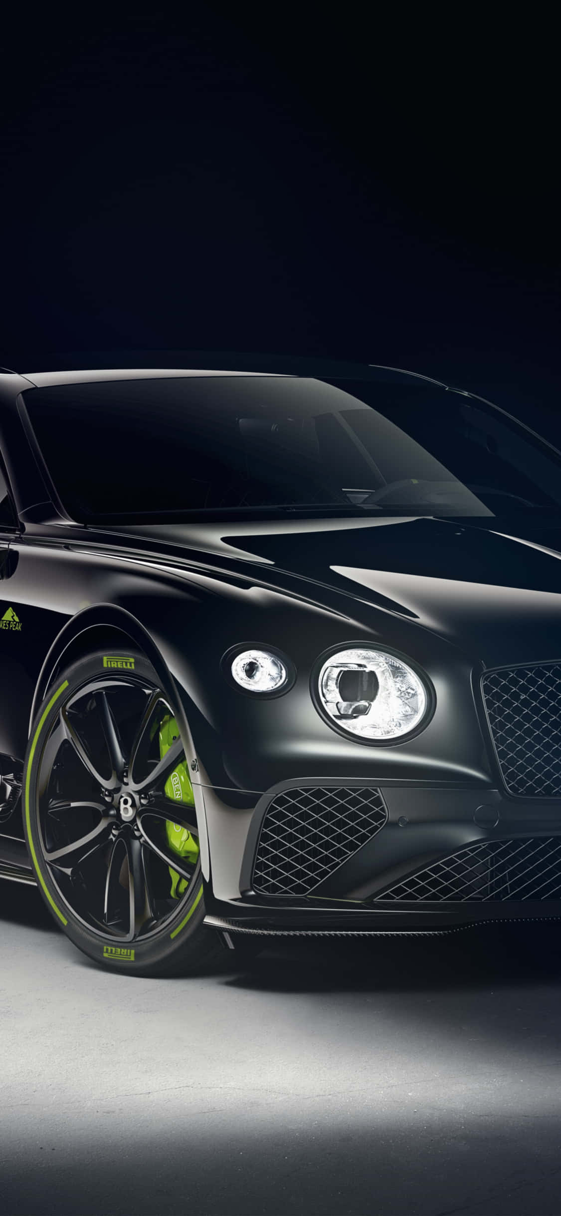 Bentley Continental Gt 桌布 壁紙 — 一輛時尚的黑色賓利，帶有螢光綠色點綴，在戲劇性的工作室燈光下閃耀。