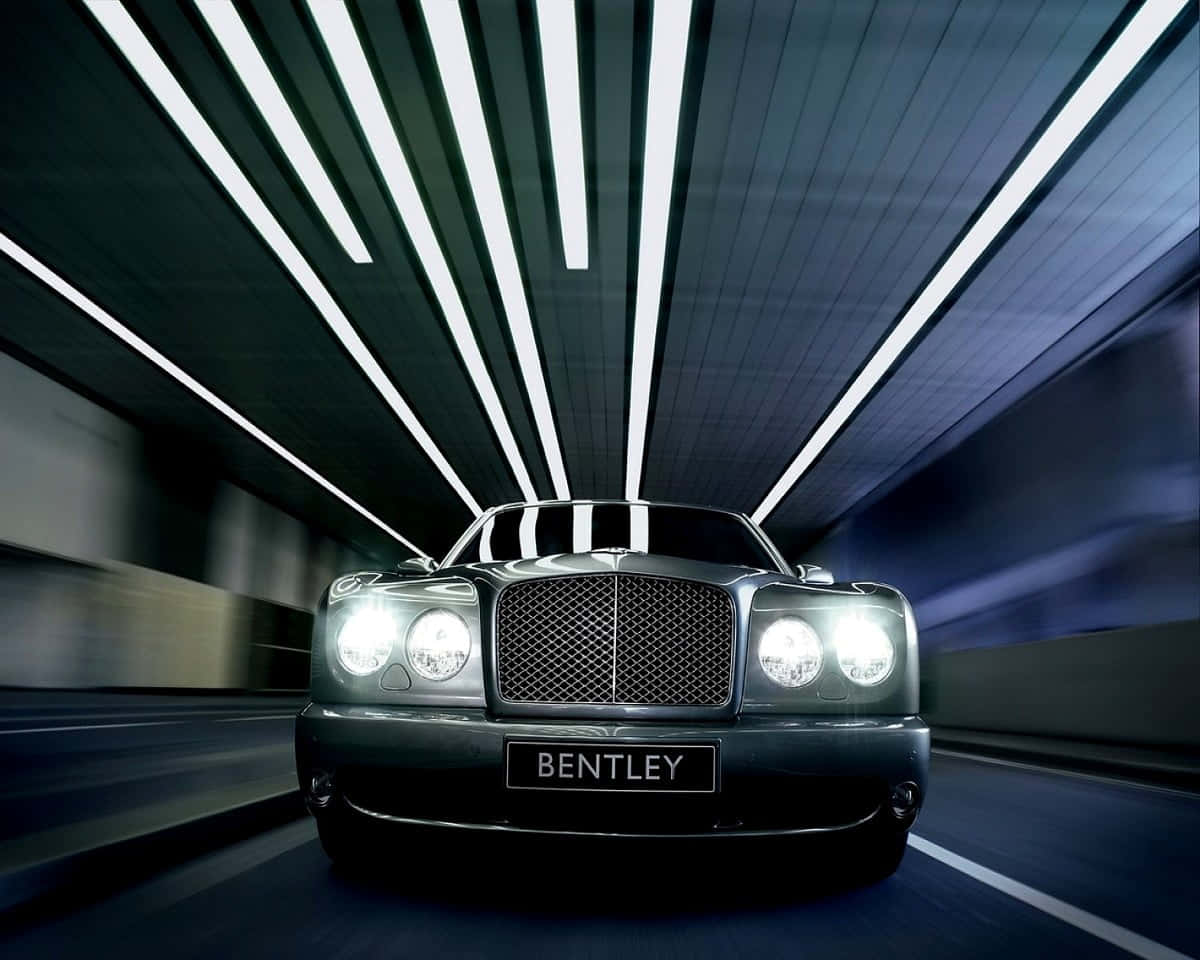Bentley Arnage 桌布 壁紙 — 一輛時尚的黑色賓利在隧道中疾馳，白色天花板燈光閃爍而過。