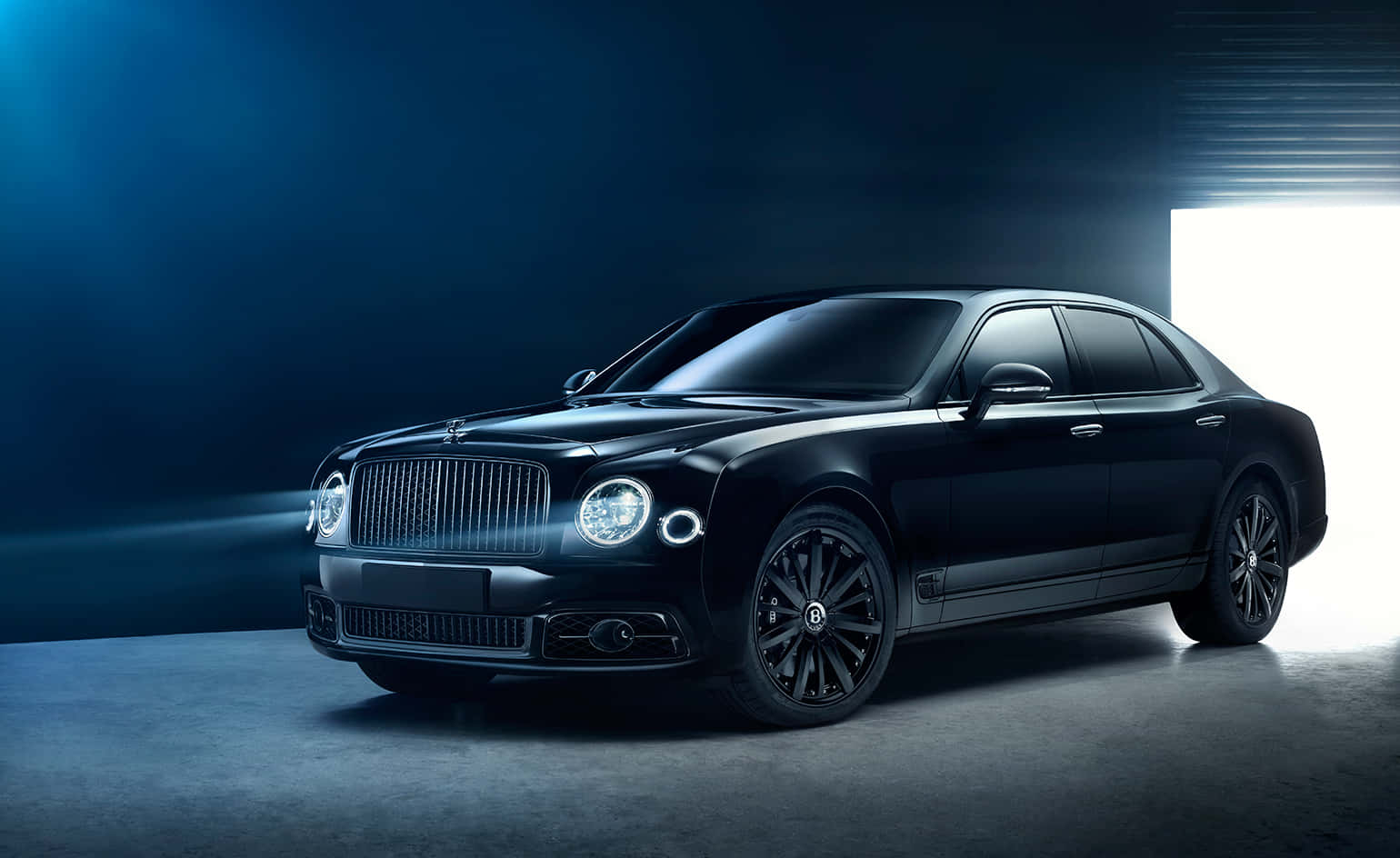 Bentley Mulsanne 桌布 壁紙 — 一輛時尚的黑色賓利轎車在戲劇性的藍色工作室燈光下閃閃發光，並帶有明亮的背光。