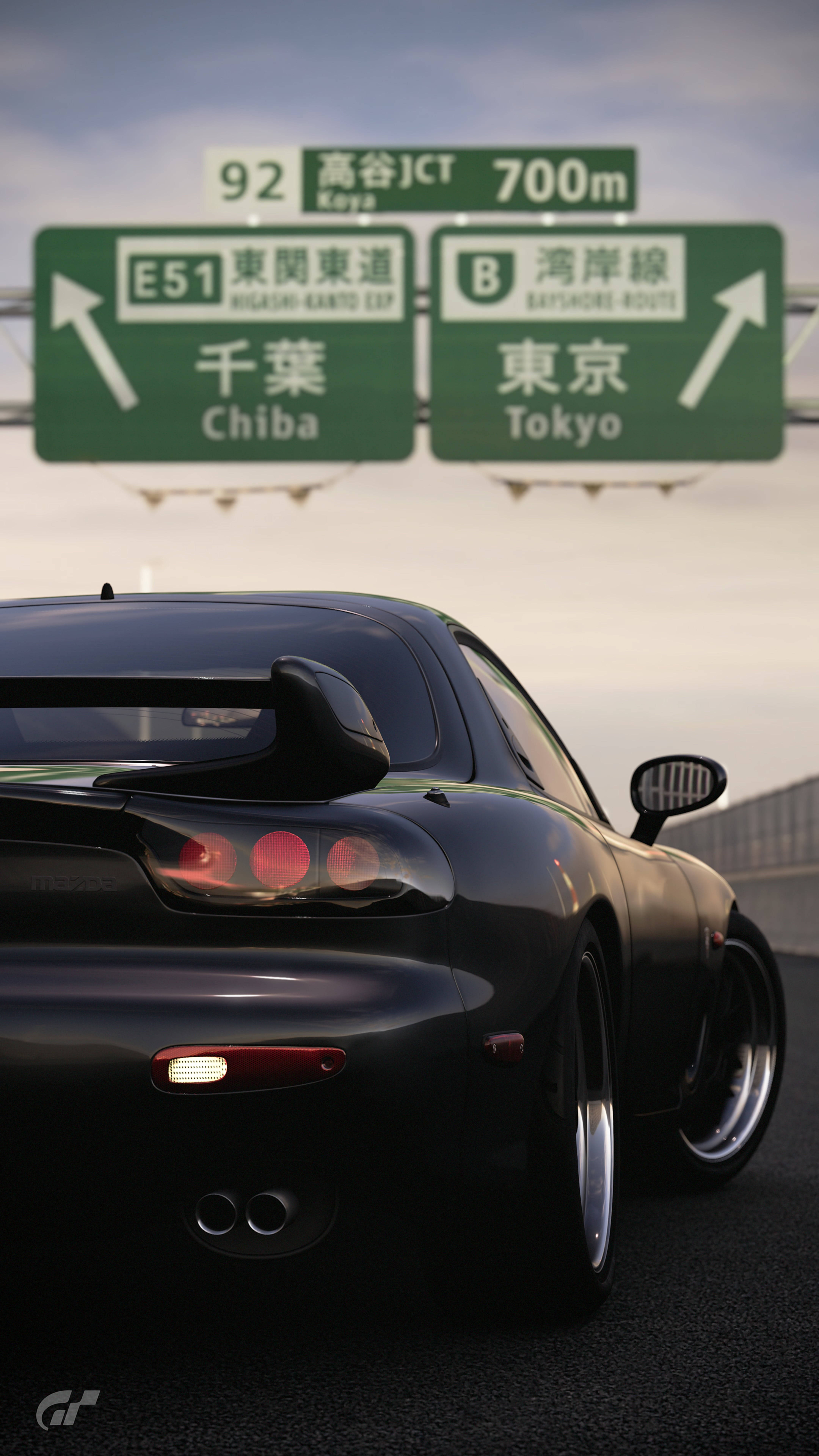 Mazda 桌布 壁紙 — 一輛時尚的黑色跑車在高速公路上行駛，下方有指向千葉和東京的綠色日本路標。