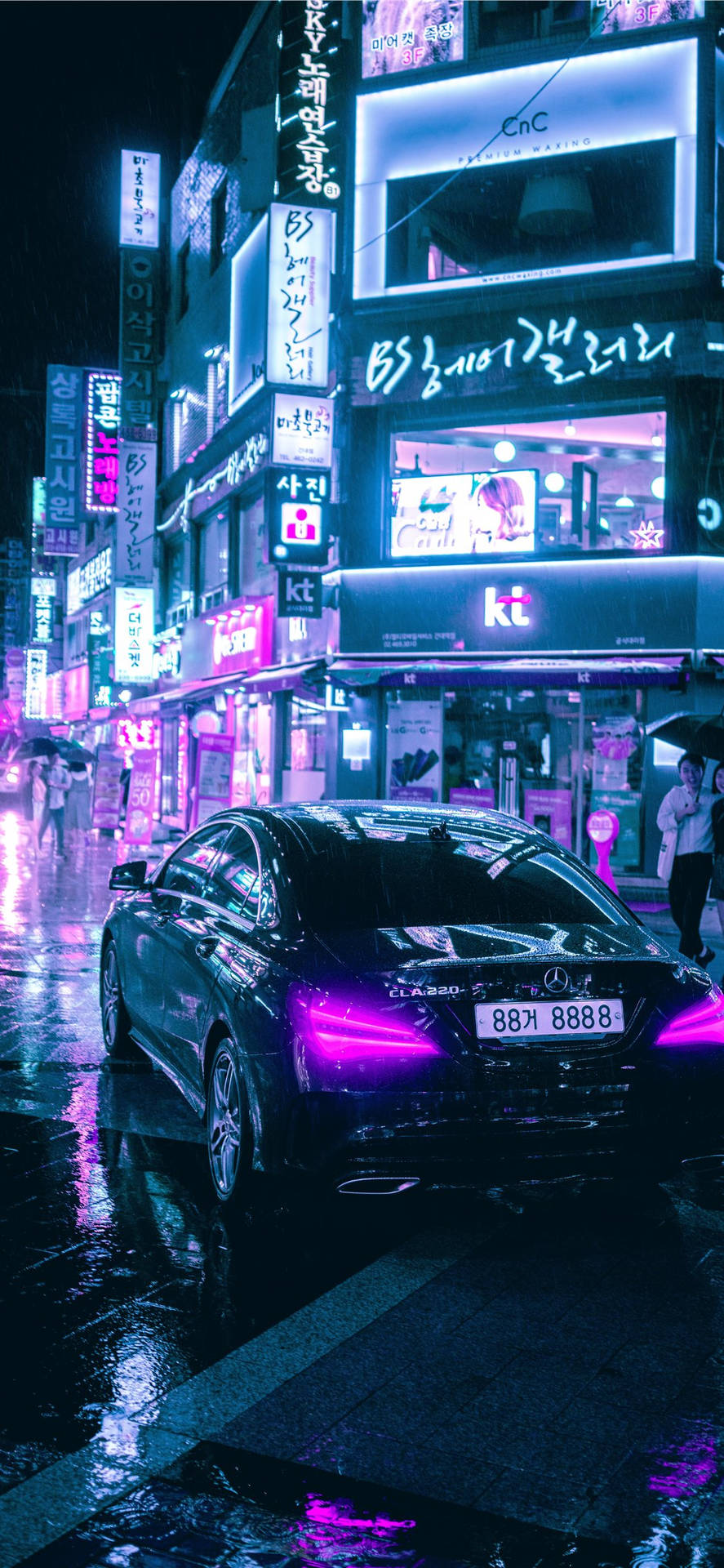 黑色汽車停在夜間潮濕的霓虹燈城市街道上