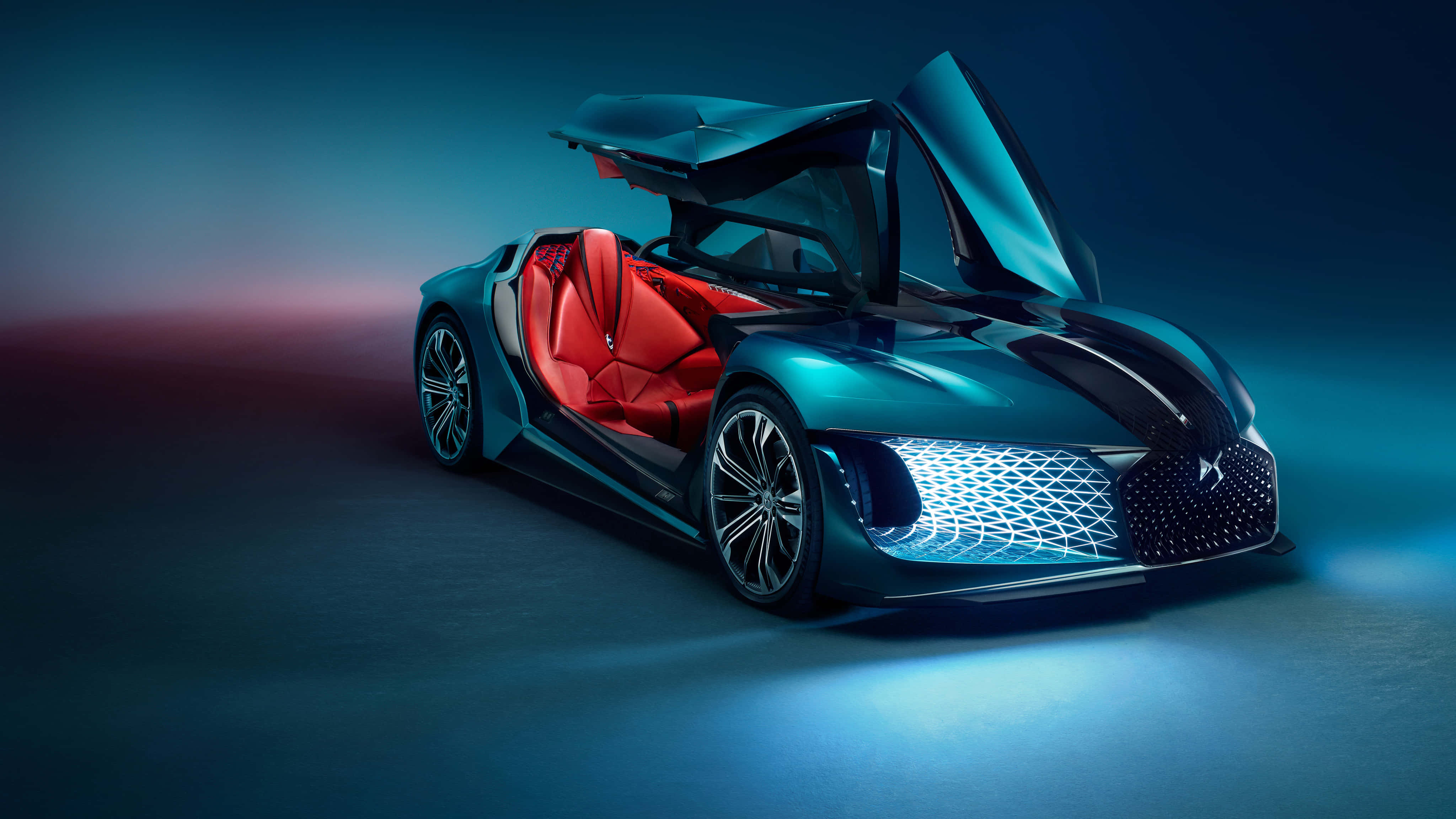 Ds Automobiles 桌布 壁紙 — 一輛未來感的水鴨藍色跑車，帶有發光的藍色飾邊和紅色內飾，置於戲劇性的攝影棚燈光下。
