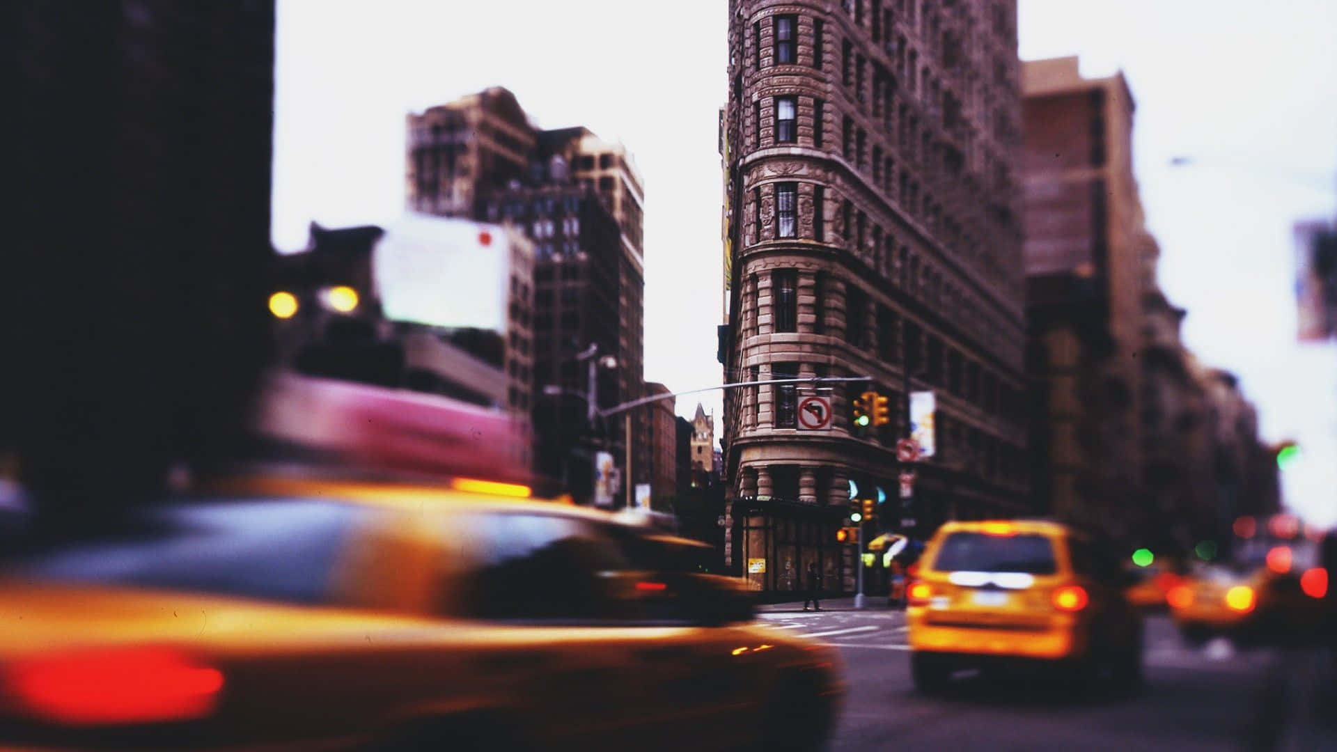 Motion Blur 桌布 壁紙 — 一輛模糊的黃色出租車在黃昏時分飛馳而過紐約市標誌性的熨斗大廈。