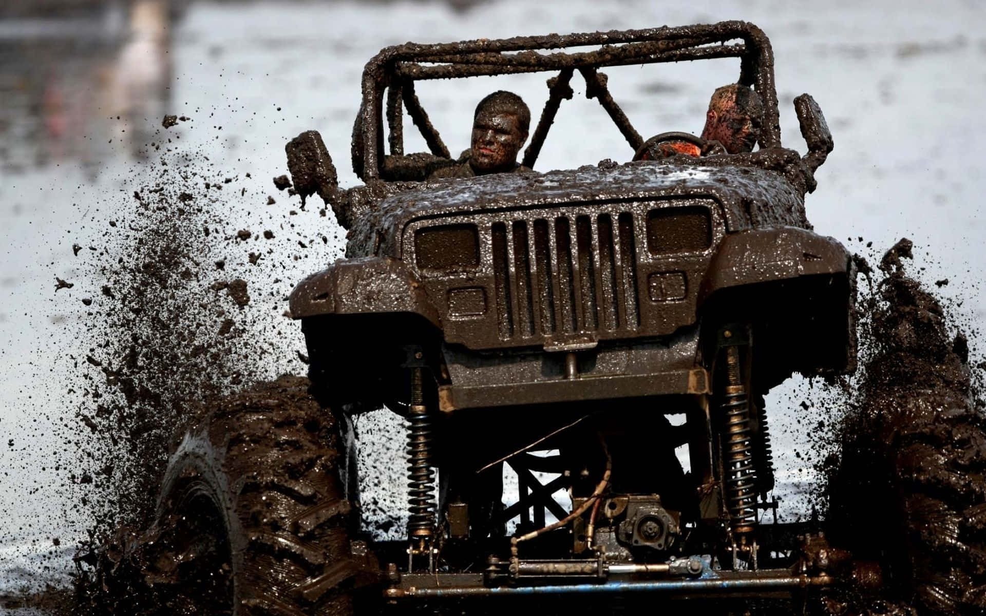 Jeep 動圖 桌布 壁紙 — 一輛泥濘的越野車在厚厚的泥漿中飛濺，敞開的車架上可見兩個滿身泥濘的騎手。