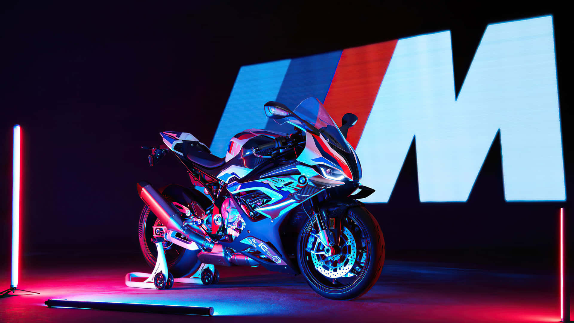 時尚的BMW M電單車在工作室中由霓虹燈照亮，背景有大型M標誌。