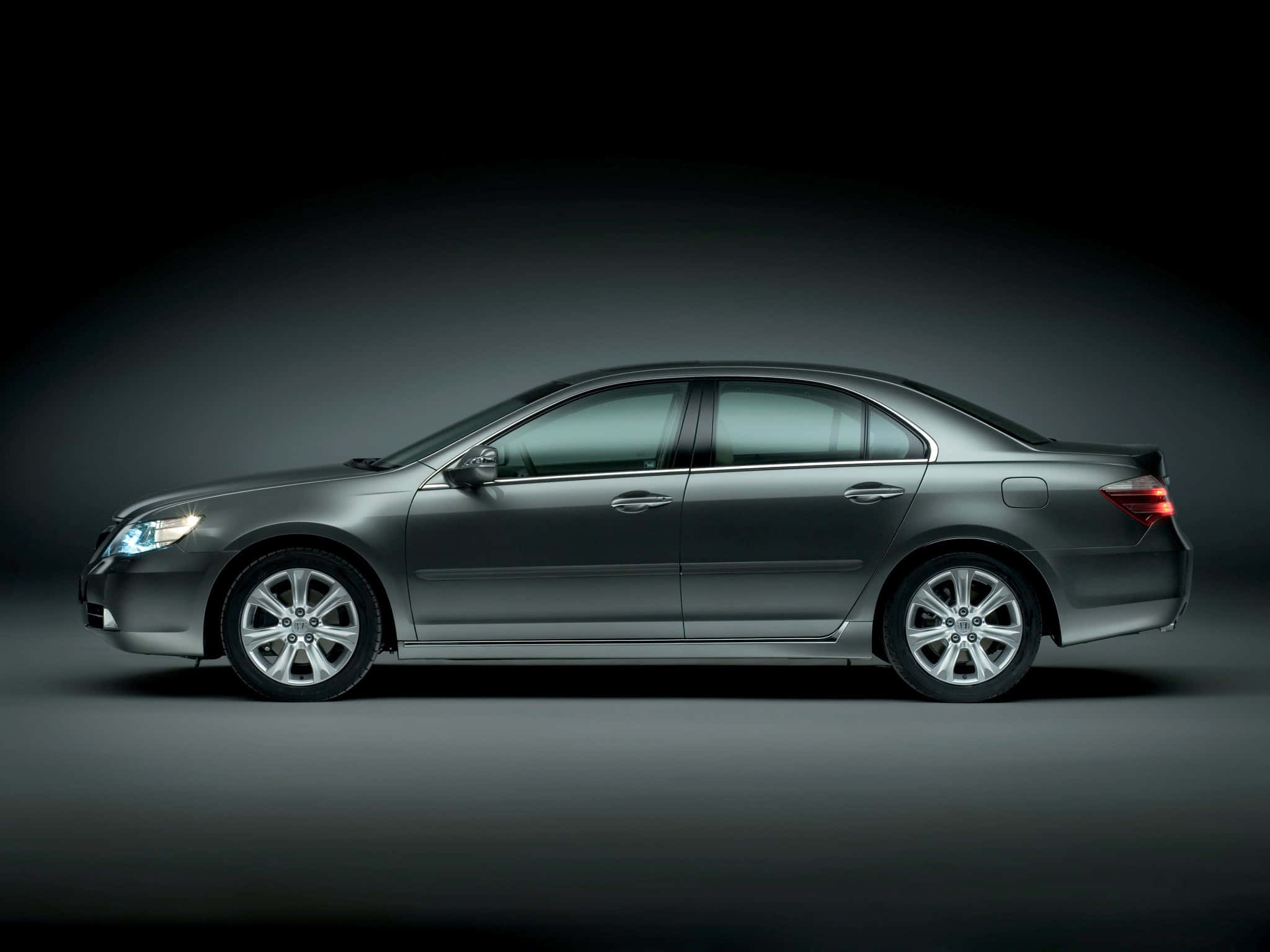 Honda Legend 桌布 壁紙 — 一輛流線型銀色轎車在側面展示，背景為深色漸變的攝影棚，光線柔和。